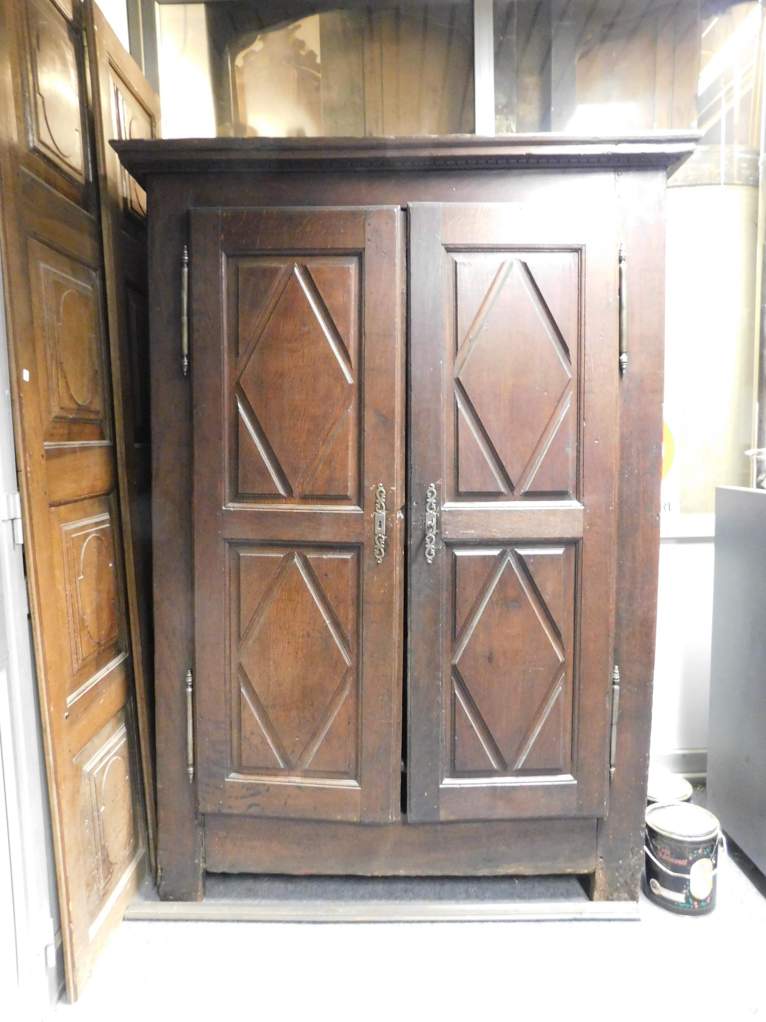 Antique wardrobe in solid oak wood, hand-carved on the sides and in the doors (double door) with lozenge-shaped tiles, built and sculpted in the middle of the 18th century in Italy.
Maximum external measurements cm w 133 x h 204 x d 58.
Brown and