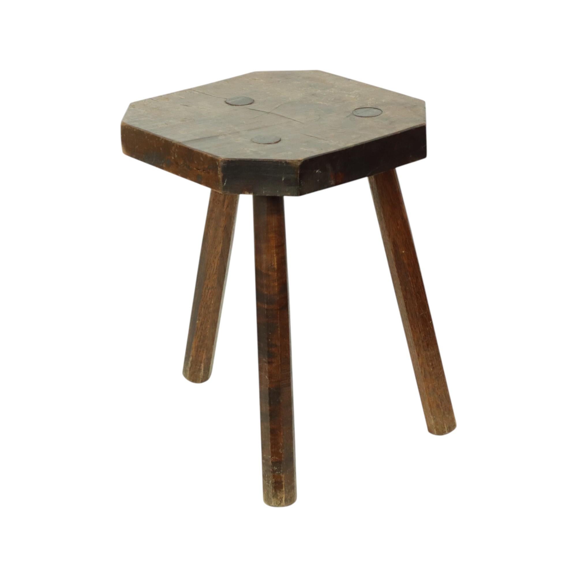 Ancien tabouret à trois pieds de caractère, un tabouret de lait en bois massif verni foncé, première moitié du 20e siècle.

Ce joli tabouret peut encore être utilisé comme siège, mais il peut aussi certainement servir de support pour les plantes. Il