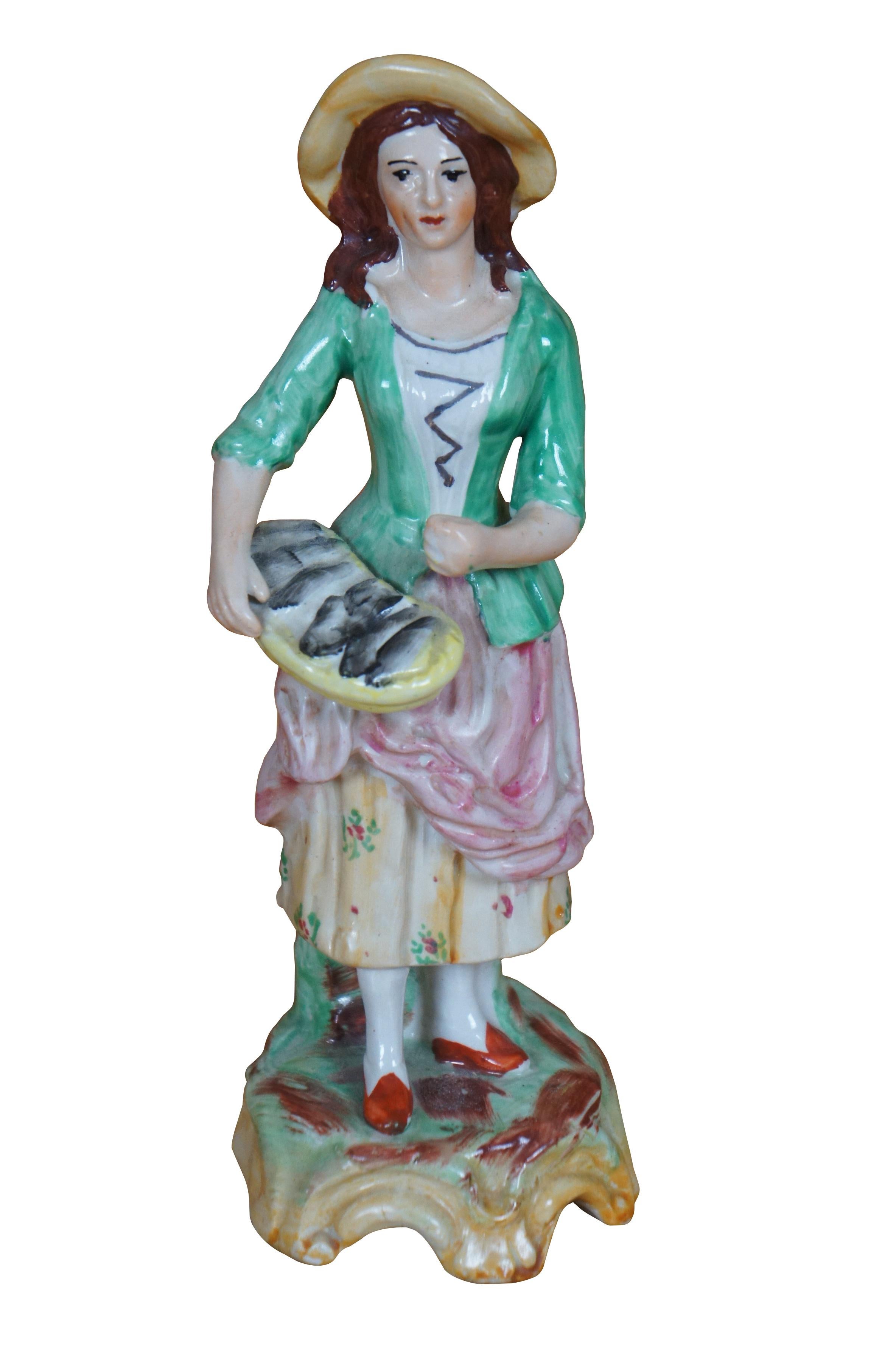 Statuette in porcellana Old Staffordshire Ware England raffiguranti una coppia di figure in verde, rosa e giallo che trasportano un cesto di pesce e fagiani/uccelli. Contrassegnato sulle basi.

Dimensioni:
2,75