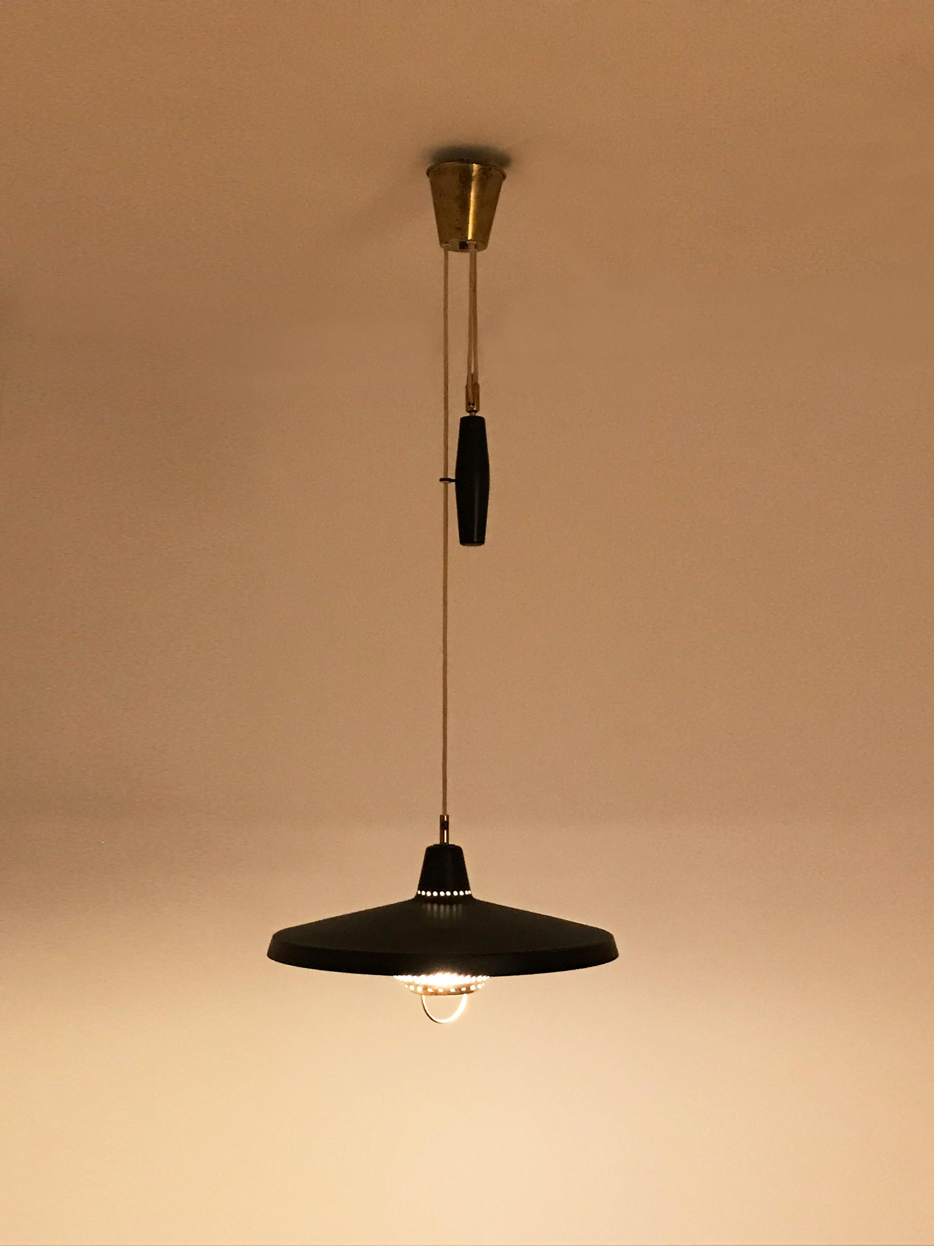 Very beautiful adjustable Swedish pendant lamp with black lacquered shade and brass elements, designed by Hans-Agne Jakobsson for Markaryd in the 1960s.
In a great original condition with manufacturer's tag.