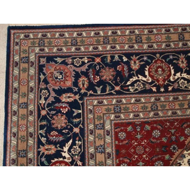 Old Persian Tabriz carpet of good almost square room size with indigo blue ground and small medallion. The carpet has a repeat small scale herati design which is very finely drawn.

The carpet is in excellent condition with almost no wear and full
