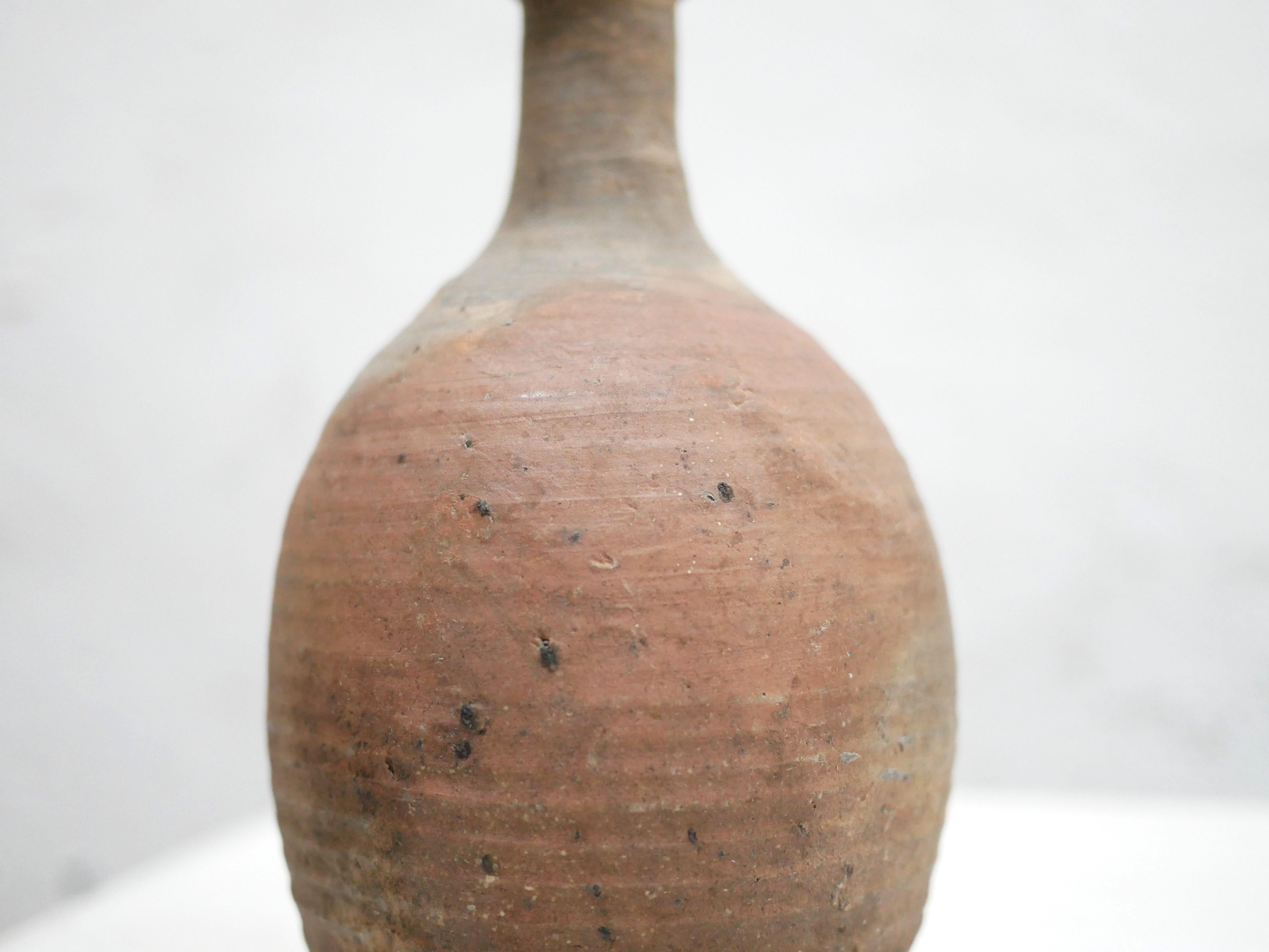 Terracotta jar dating from the 60s.

With its modern shape and mineral color, this ceramic will be perfect in a natural, refined and delicate decoration.
We simply imagine it placed on a shelf or a piece of furniture, decorated with a few dried