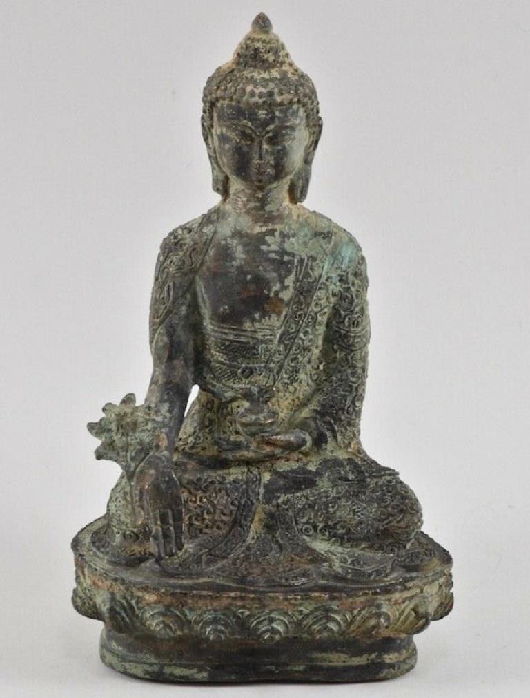 Antique Tibetan bronze Medicine Buddha statue, seated on a lotus pedestal holding a healing sprig of Myrobalan and a medicine jar, Tibet, 18th century. This Medicine Buddha, also called 