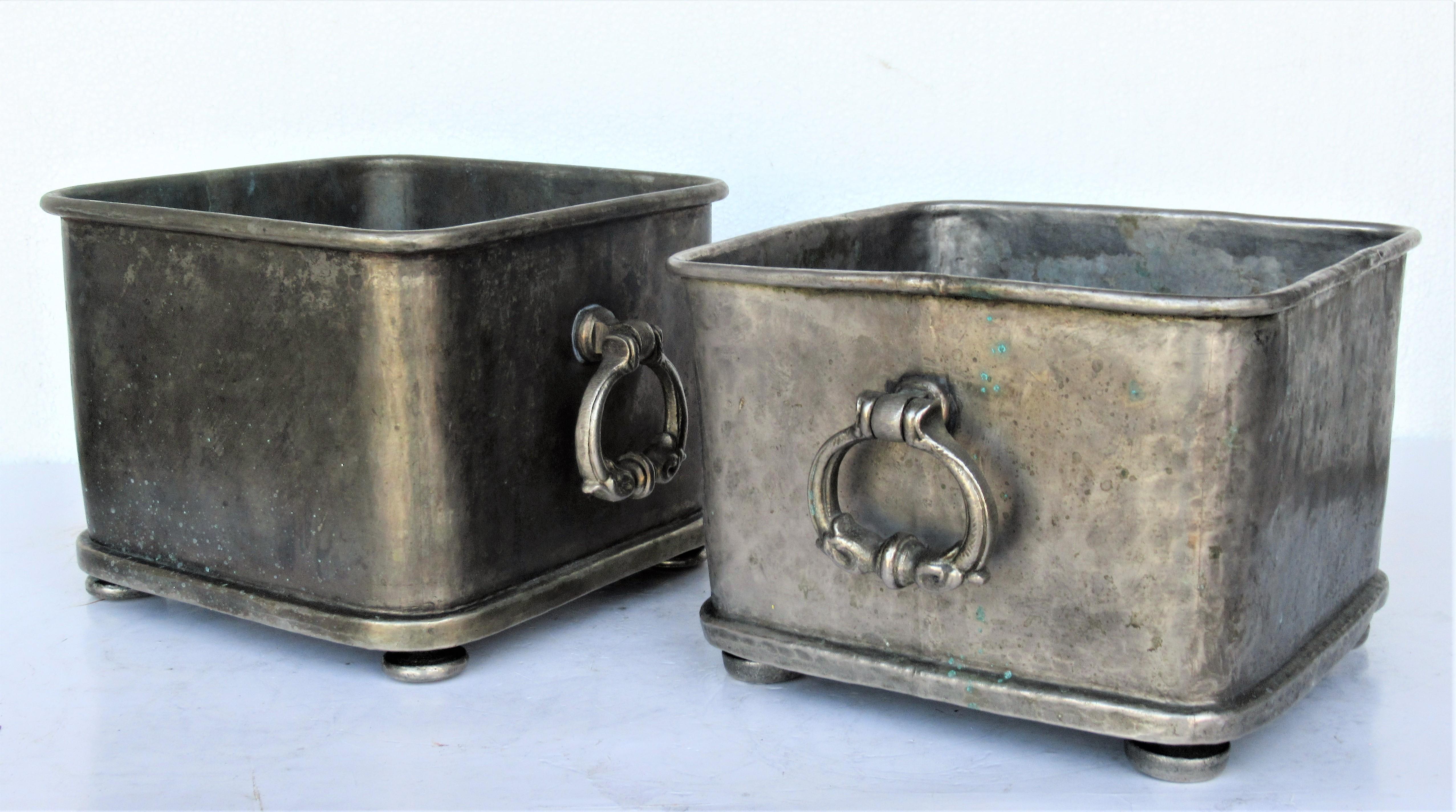 Pair of old silver tinned bronze tabletop cachepot planters - each with four bun feet and decorated swing handles at two sides. Cast stamped on underside Mauritius with crown mark, Made in Italy, a tree branch design with numbers and letters, paper