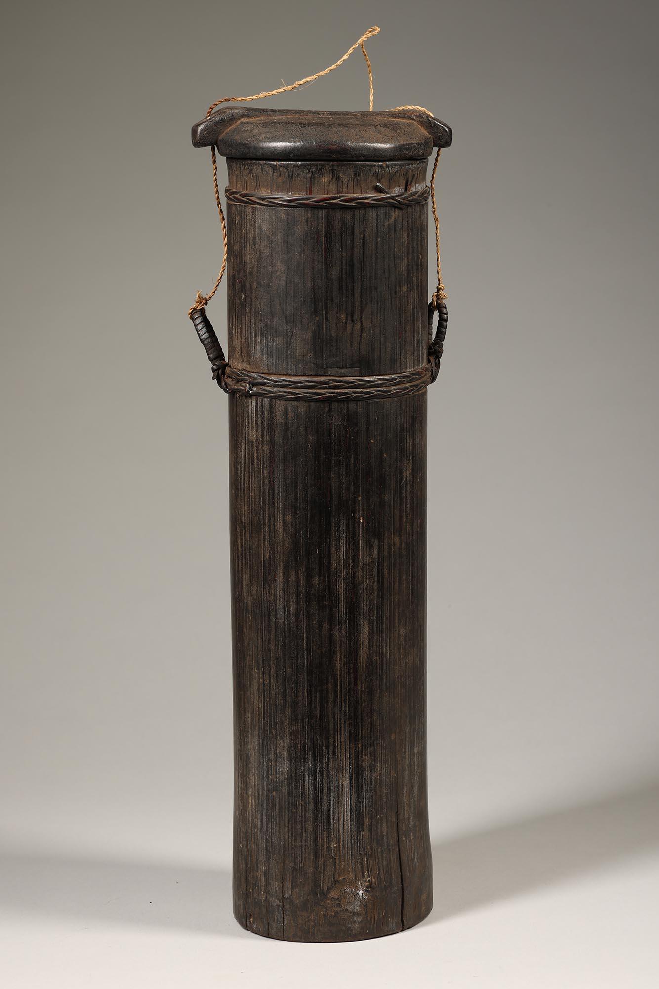 Old well used tall rice container carved from bamboo, with wood top from the island of Toraja, Indonesia.  Early to mid 20th century or earlier, with deep dark patina from traditional use.  Old stable cracks at base.  Separately carved and attached