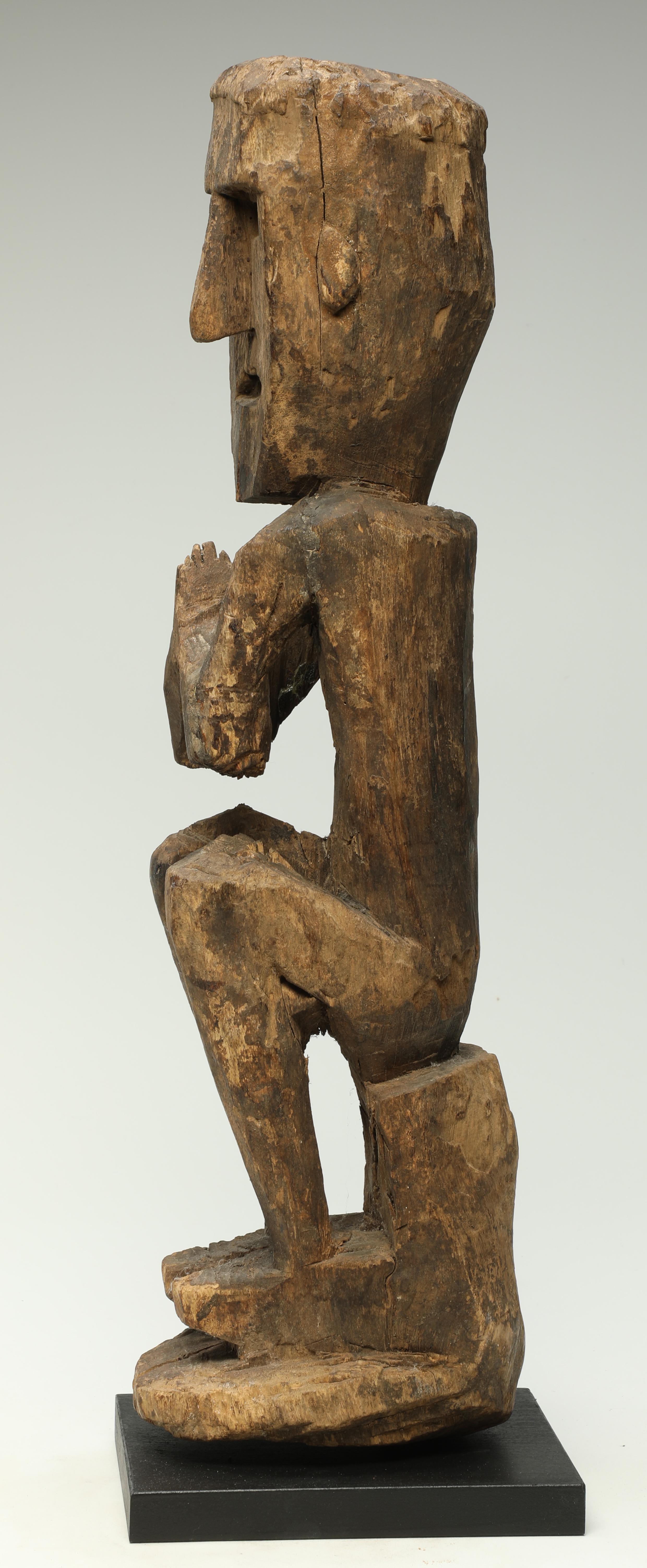 Vieille figure cubiste accroupie en bois sculpté tribal avec les mains levées en position namaste. Merveilleuse figure de forme ouverte avec les mains devant la poitrine et un grand profil. Il s'agissait de figures de protection utilisées au Népal.