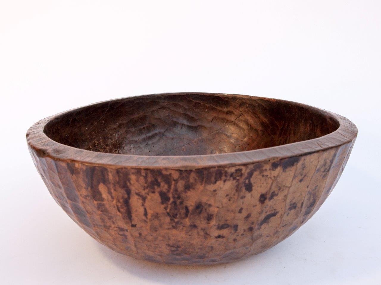 Old tribal wooden bowl from West Nepal Himal, 16 inch diameter mid-20th century.
This bowl is hand hewn from a single piece of local wood. Years of use in the rugged conditions of a west Nepal household have lent it a rich patina, and the hand