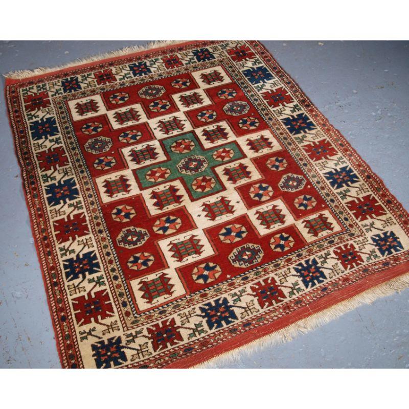 Old Turkish Bergama rug of traditional village design.

The rug has a traditional box design with the central area in green, each box is filled with a star or other device. The border is ivory ground with a repeat design.

The rug retains original