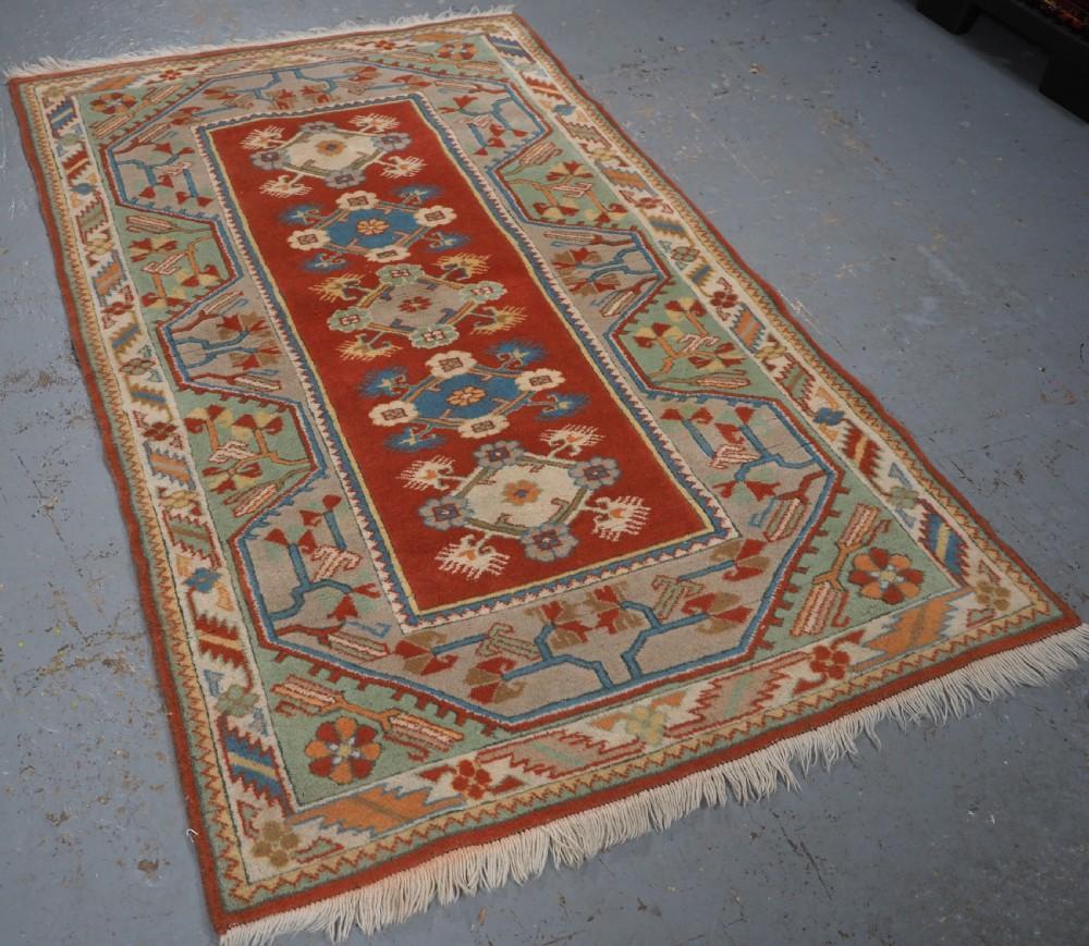 Alter türkischer Milas Teppich mit traditionellem Design und sehr guten weichen Pastellfarben
CIRCA 1960

Der Teppich hat fünf kleine florale Rosettenmedaillons auf einem sehr weichen roten Grund Die traditionellen Bordüren in Pastelltönen rahmen