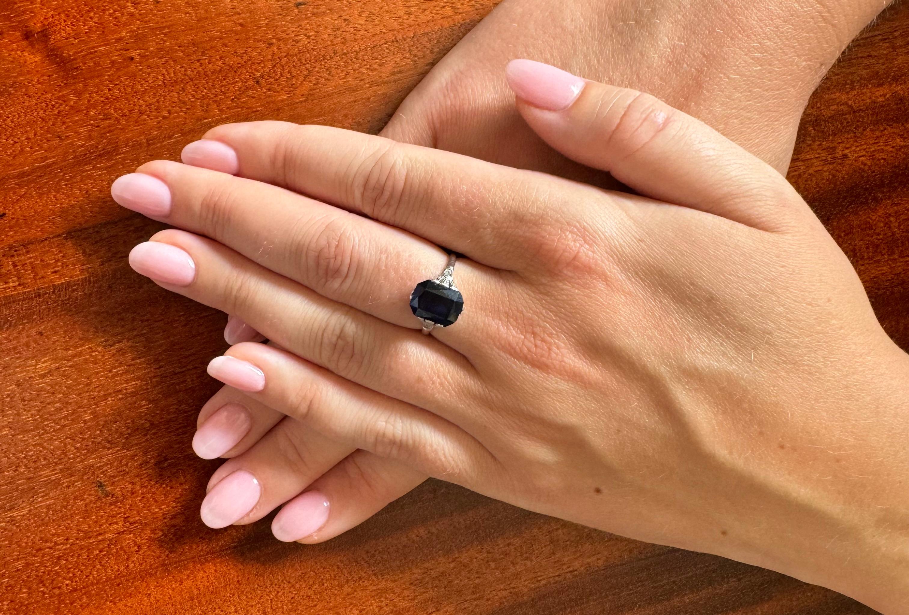 Vintage ring made of 18-carat white gold. 
Its centerpiece is a faceted, rectangular synthetic sapphire weighing approximately 4.00 carats. Sapphire is distinguished by its beautiful, deep blue color. Synthetic sapphire means that it was created by