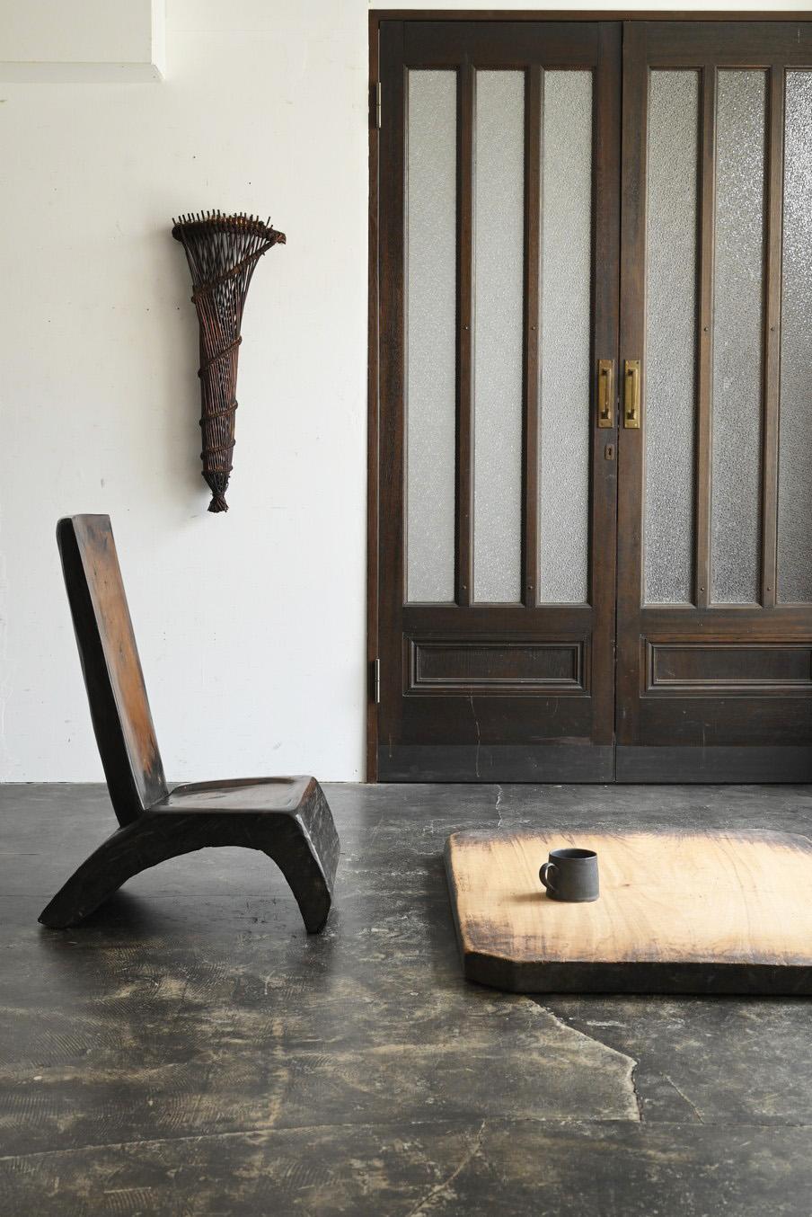 Il s'agit d'une chaise basse en bois qui aurait été fabriquée dans une région comme l'Asie du Sud-Est. Avec son dossier haut et son assise basse, il se marie à merveille avec des tables au sol ou des tables basses, ce qui en fait un meuble idéal