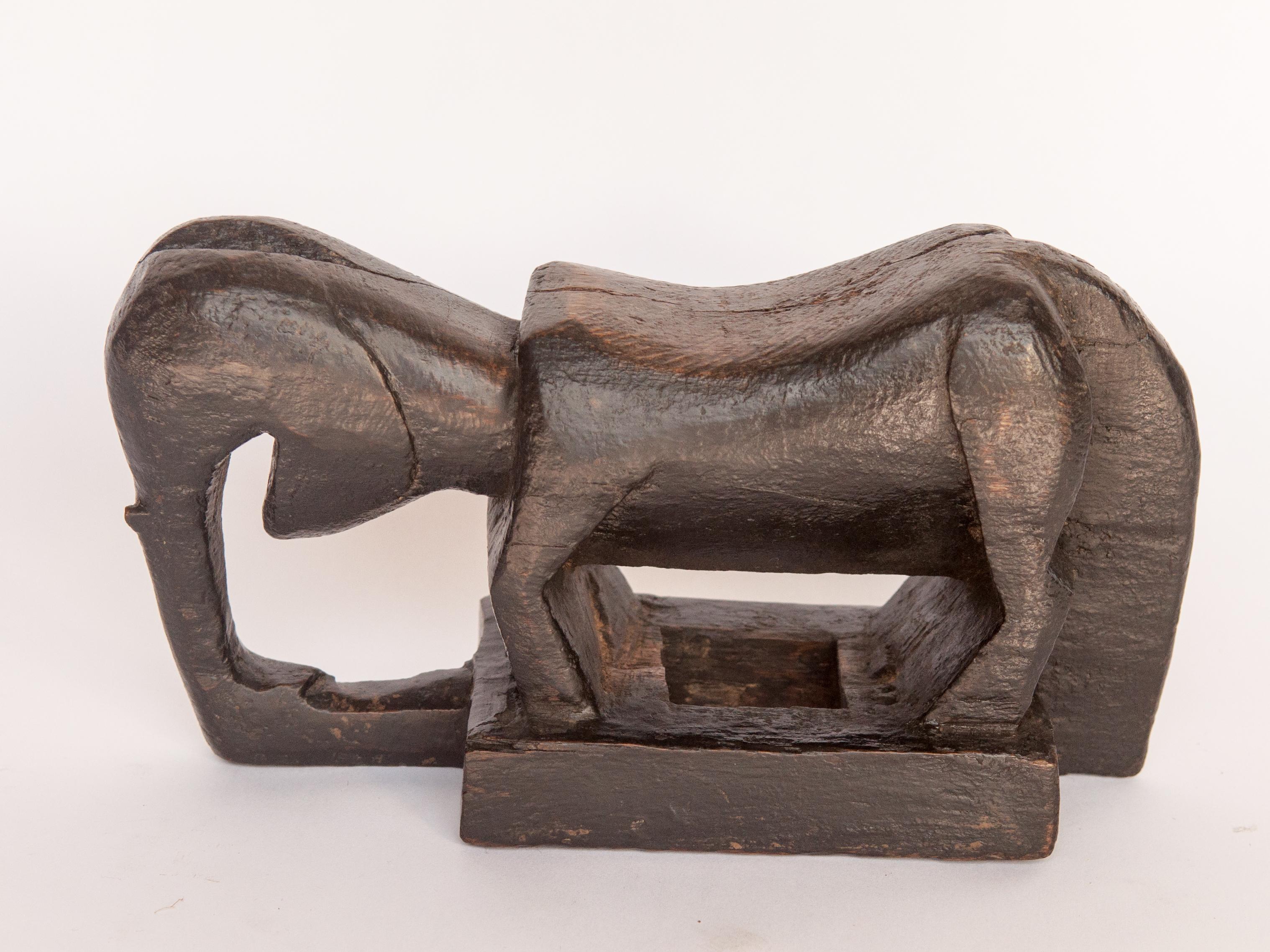 Old wooden staff carving. Stylized elephant Motif. From the Tharu People of Nepal, mid-20th century.
This carving formed the end piece of a large carrying staff, used to support a heavy load during rest intervals during transport. Such staffs were