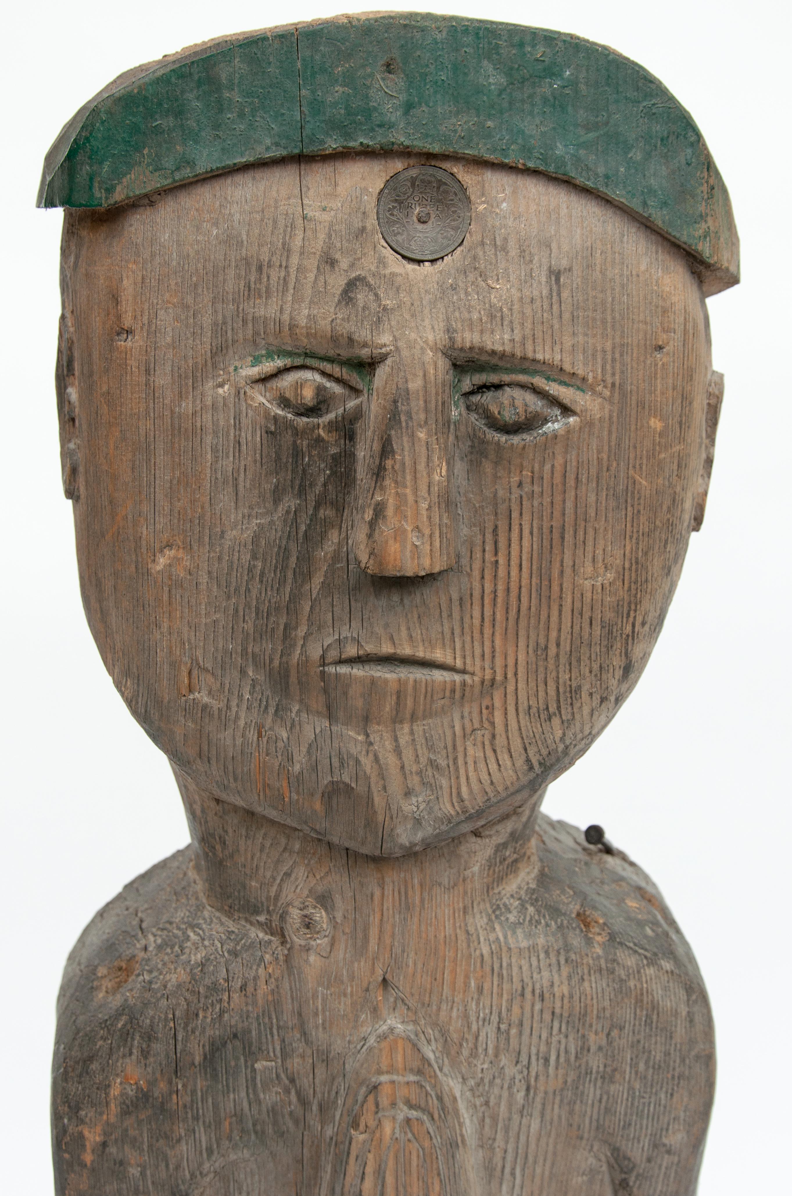 Wooden tribal statue from West Nepal, mid-20th century. Steel plate base.
This wooden figure comes from West Nepal, most likely from the area of the Karnali river system. He wears a green topi or hat in the shape of the crescent moon and has an old