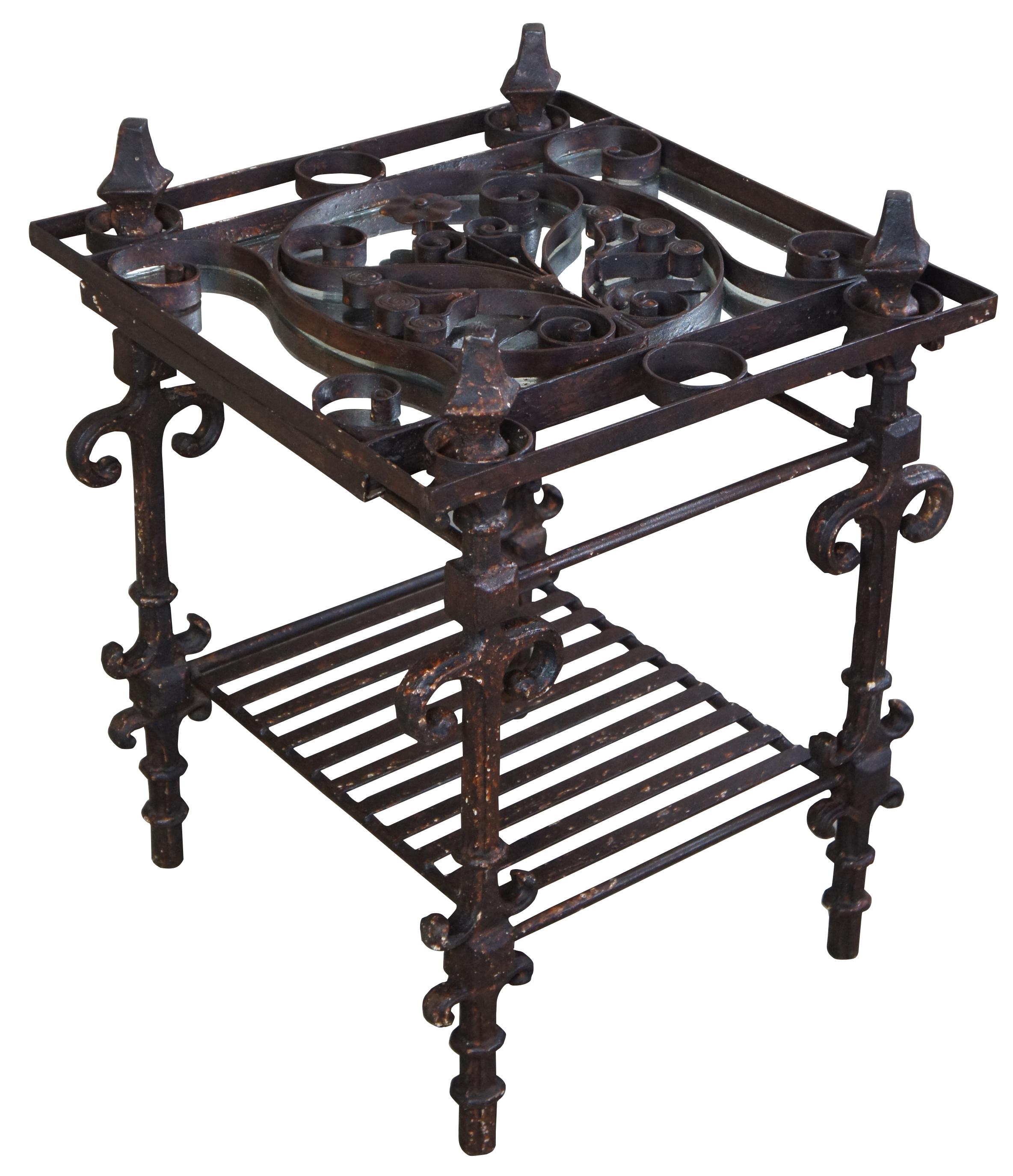 Rustic iron side table by Arhaus Furniture. Features a two-tier design with mirrored top, floral and scrolled accents in a rustic brown finish. Very Heavy.
 