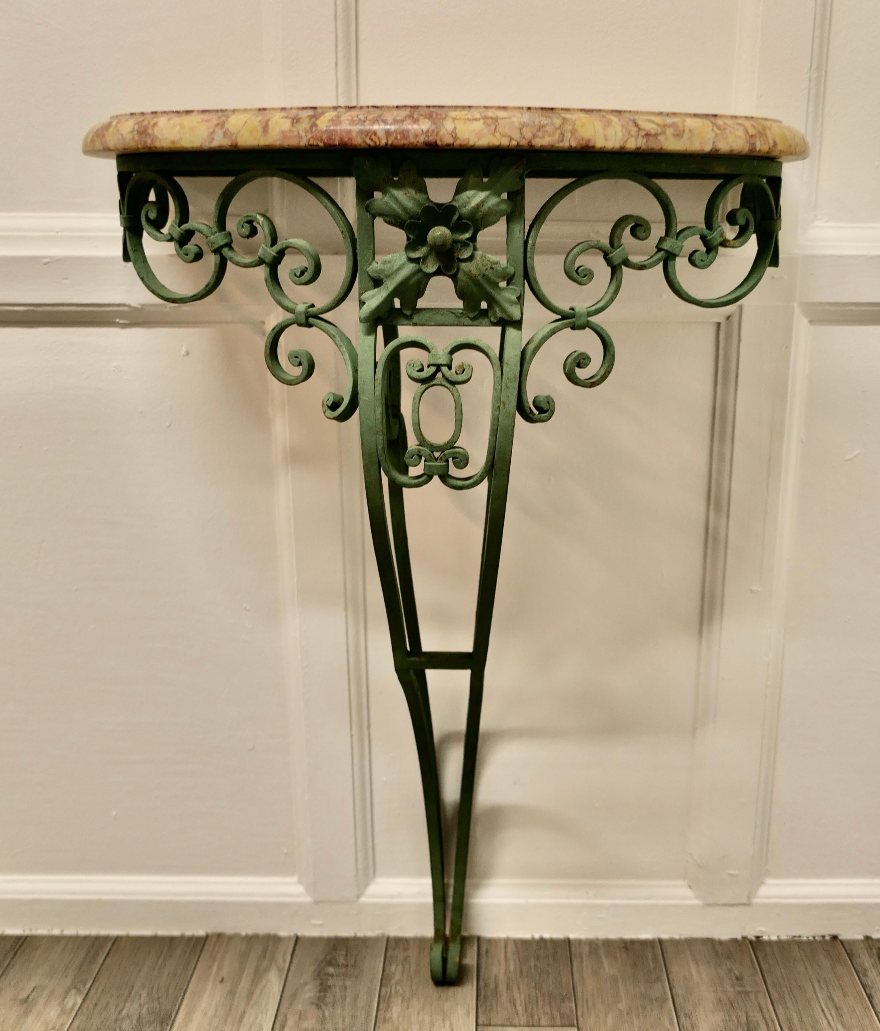 Old Wrought Iron French Marble Console or Hall Table

This is a very attractive piece, the table has decorative scroll and shell decoration to the iron leg which is in a shabby moss green
The table top is a curved shape with a pink and peach