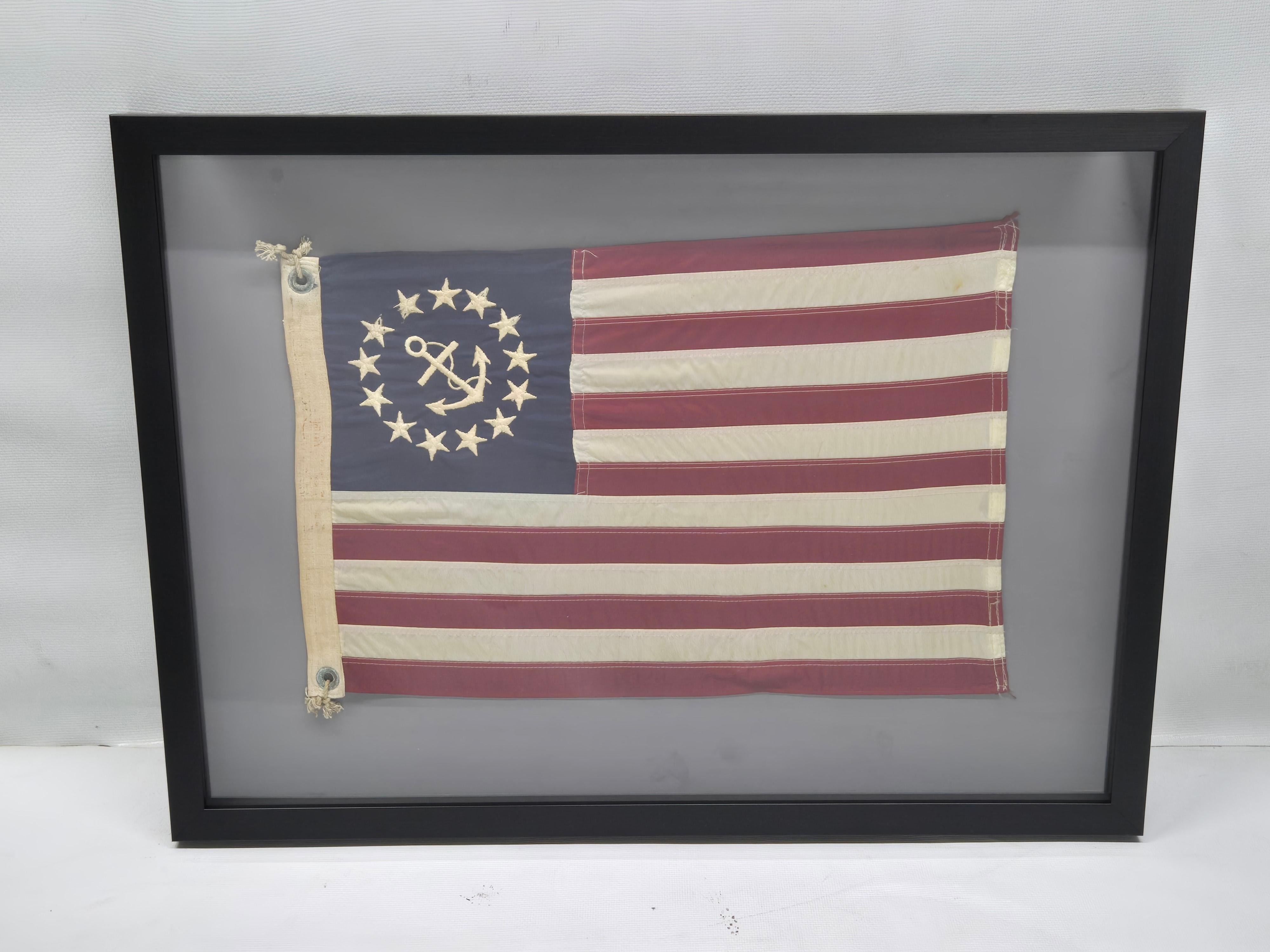 Bandera de barco antigua con un ancla sucia y trece estrellas en el campo azul. La enseña de yates de Estados Unidos fue creada por el Congreso en 1848 para identificar a los yates que no necesitaban pasar la aduana al entrar en los puertos. Indica