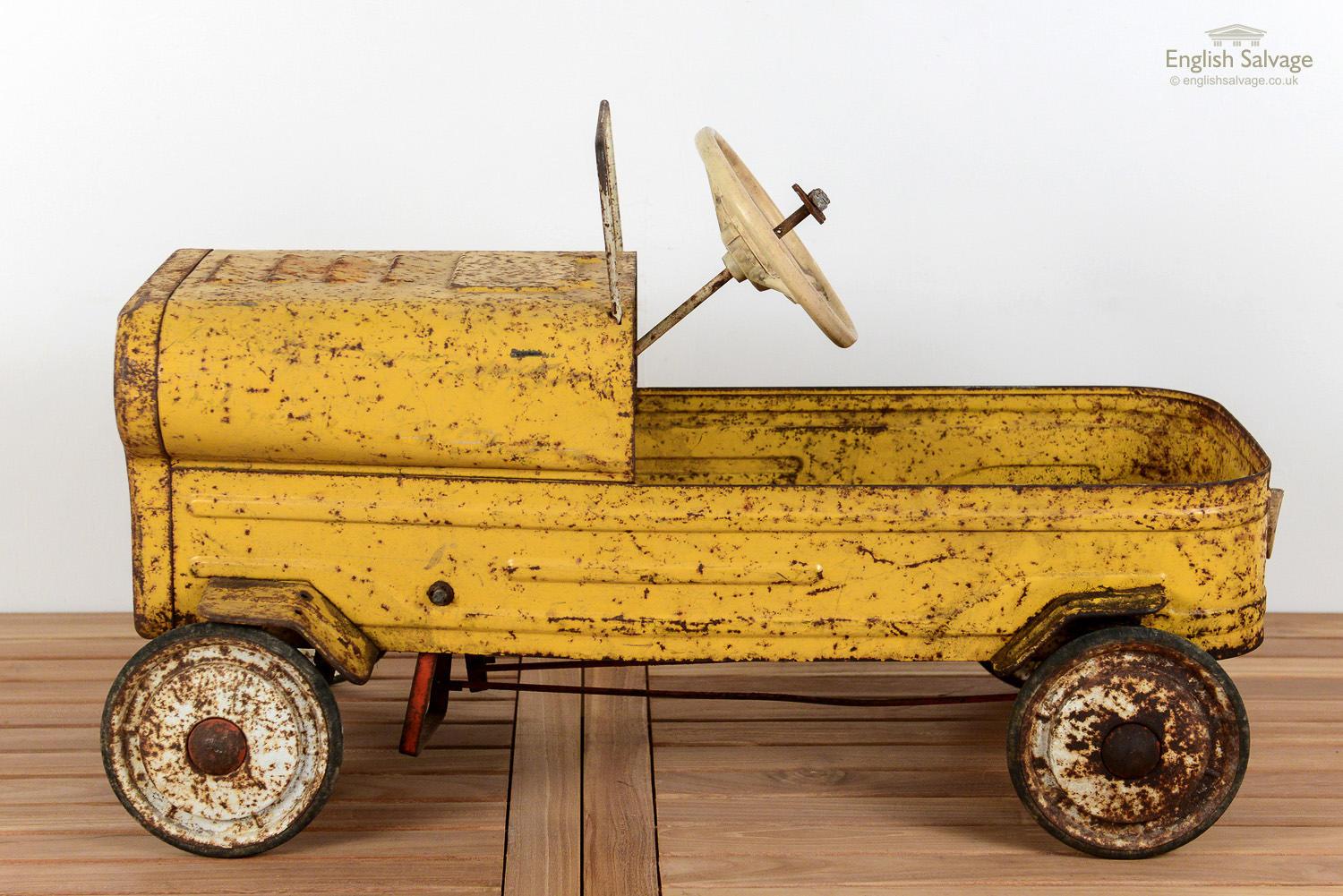 Vintage ride on metal car, probably dating from the 1950s. Surface rust throughout, and the steering column is not functioning, but it appears to be repairable. It resembles a Hamilton US army jeep, and has radiator vents and engine vents, and