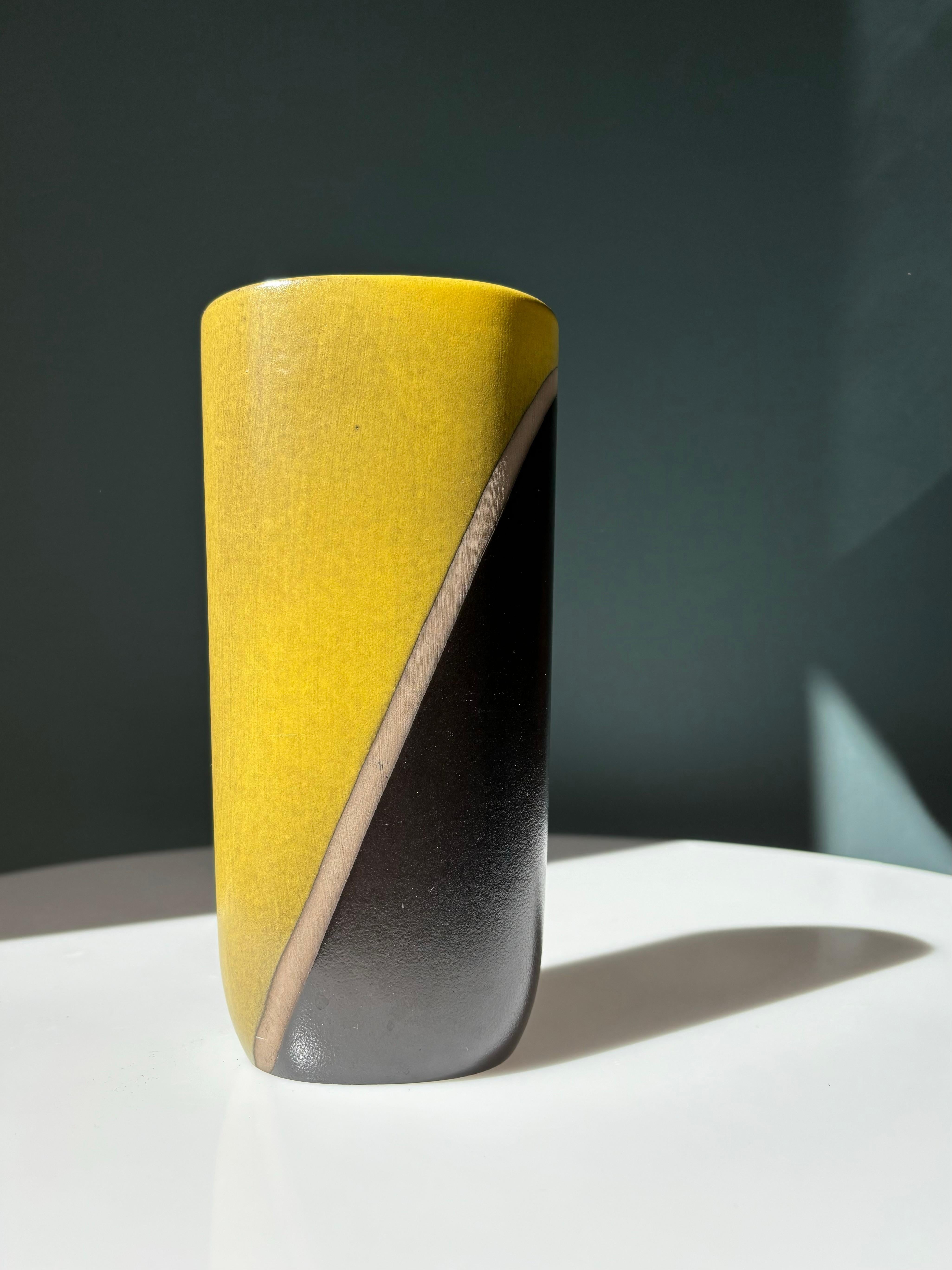 Vase suédois Modern-Decor de forme ovale avec un décor géométrique fort. Émail vert thé poussiéreux et noir anthracite séparés par une ligne diagonale non émaillée au milieu. Conçue et fabriquée à la main par Hjördis Oldfors (1920-2014), né à
