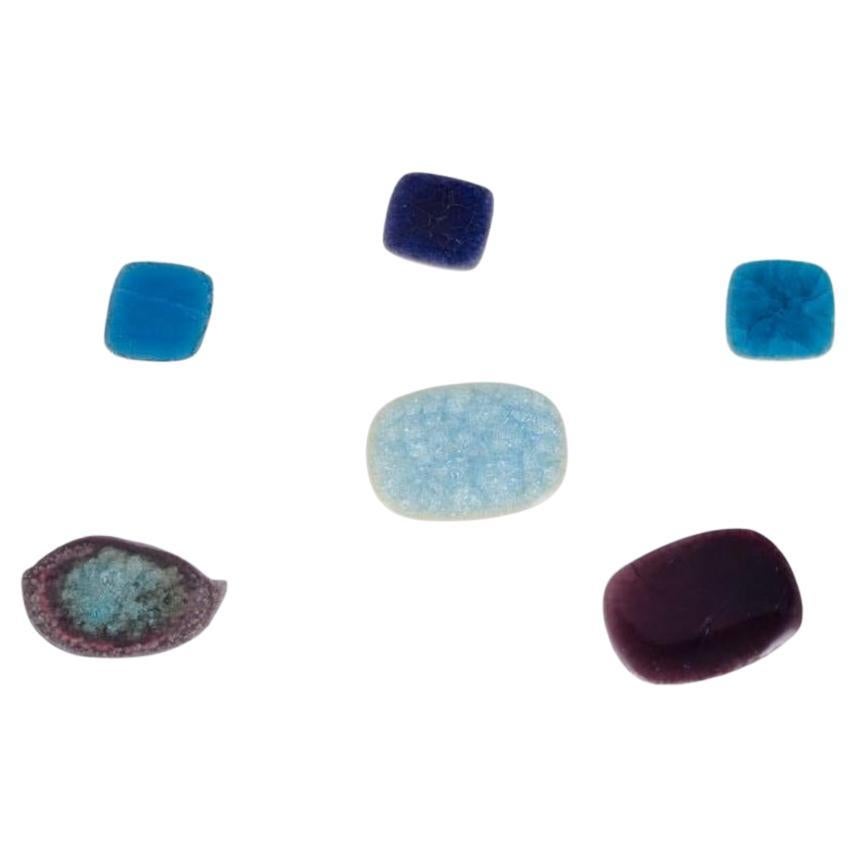 Ole Bjørn Krüger. Six unique glazed stoneware brooches in blue and purple hues.