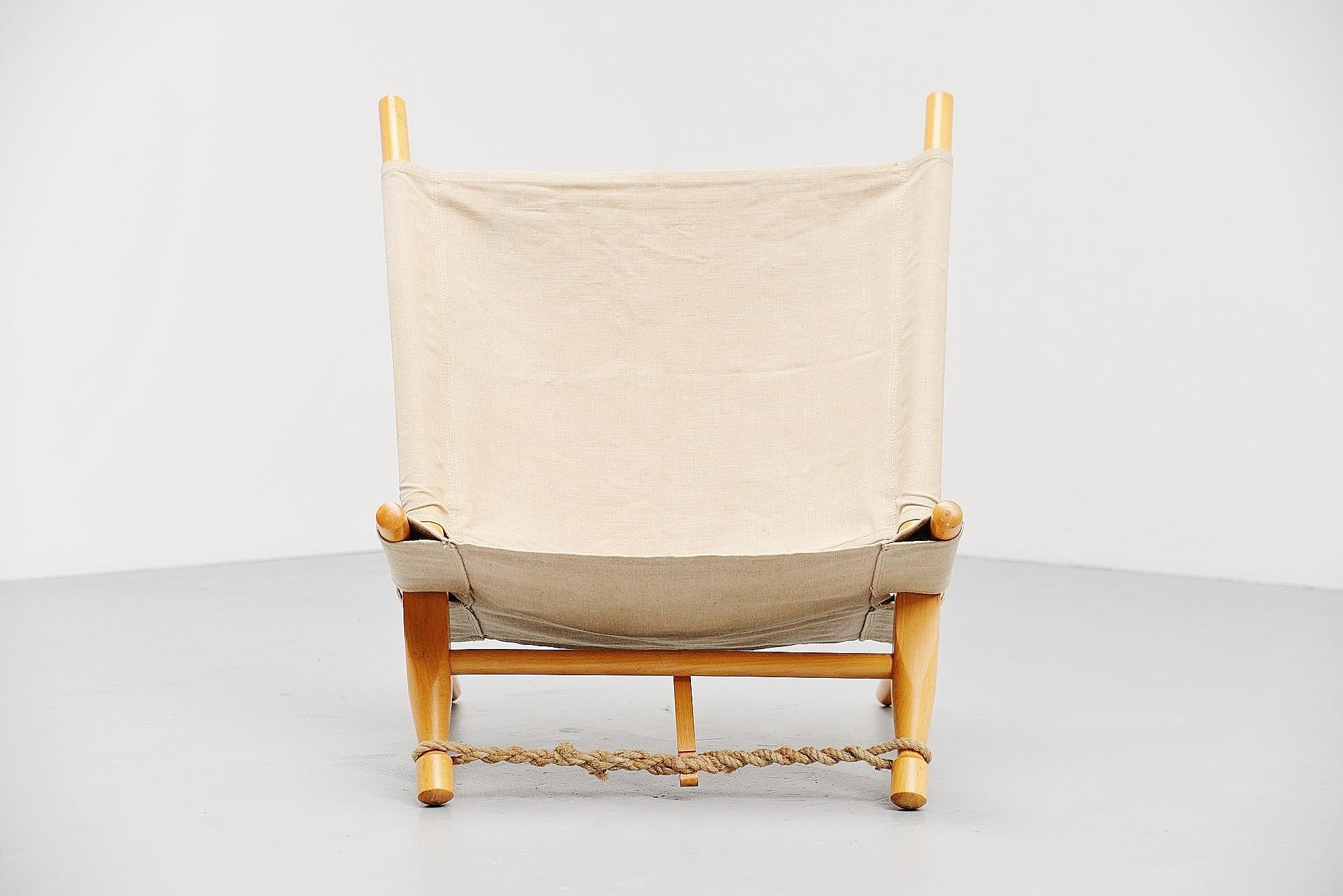 Very nice dynamic low lounge chair designed by Ole Gjerløv-Knudsen, manufactured by Cado, Denmark, 1958. The chair has a birch wooden frame existing in 4 parts sliding in each other to change the angle if wanted. The canvas seat and the rope