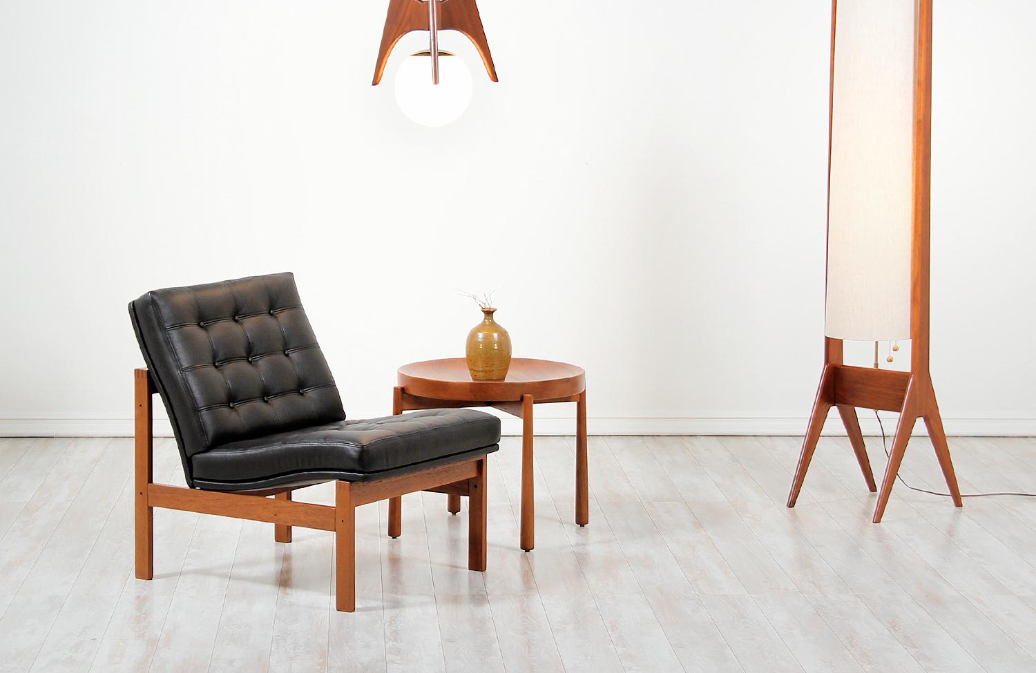 Stylish ‘Moduline’ lounge chair designed by Ole Gjerløv-Knudsen and Torben Lind for France & Søn in Denmark in 1962. This gorgeous example of modern Danish design features a sturdy teak wood frame with an angled seat newly upholstered in black