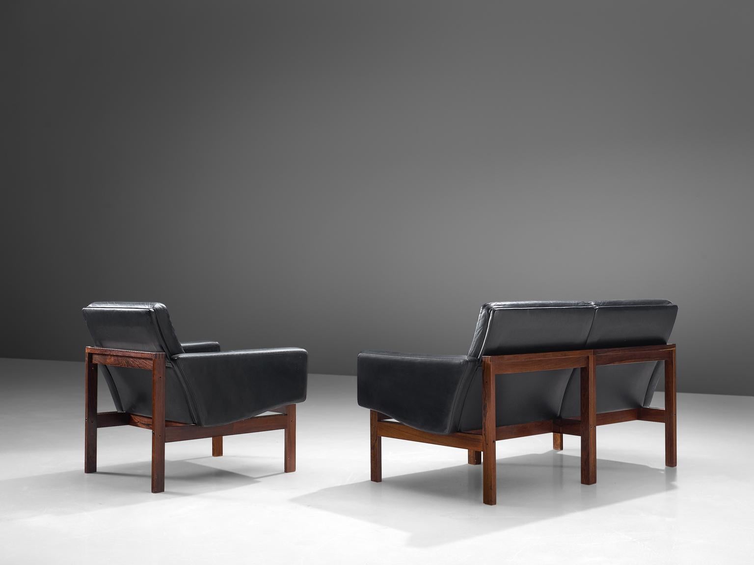Ole Gjerløv-Knudsen for France & Son, living room set, Denmark, 1962.

This chair and sofa form an extraordinary stately set, being both crisp and warm at the same time. The teak frame holds a black leather body with buttoned cushions. The original