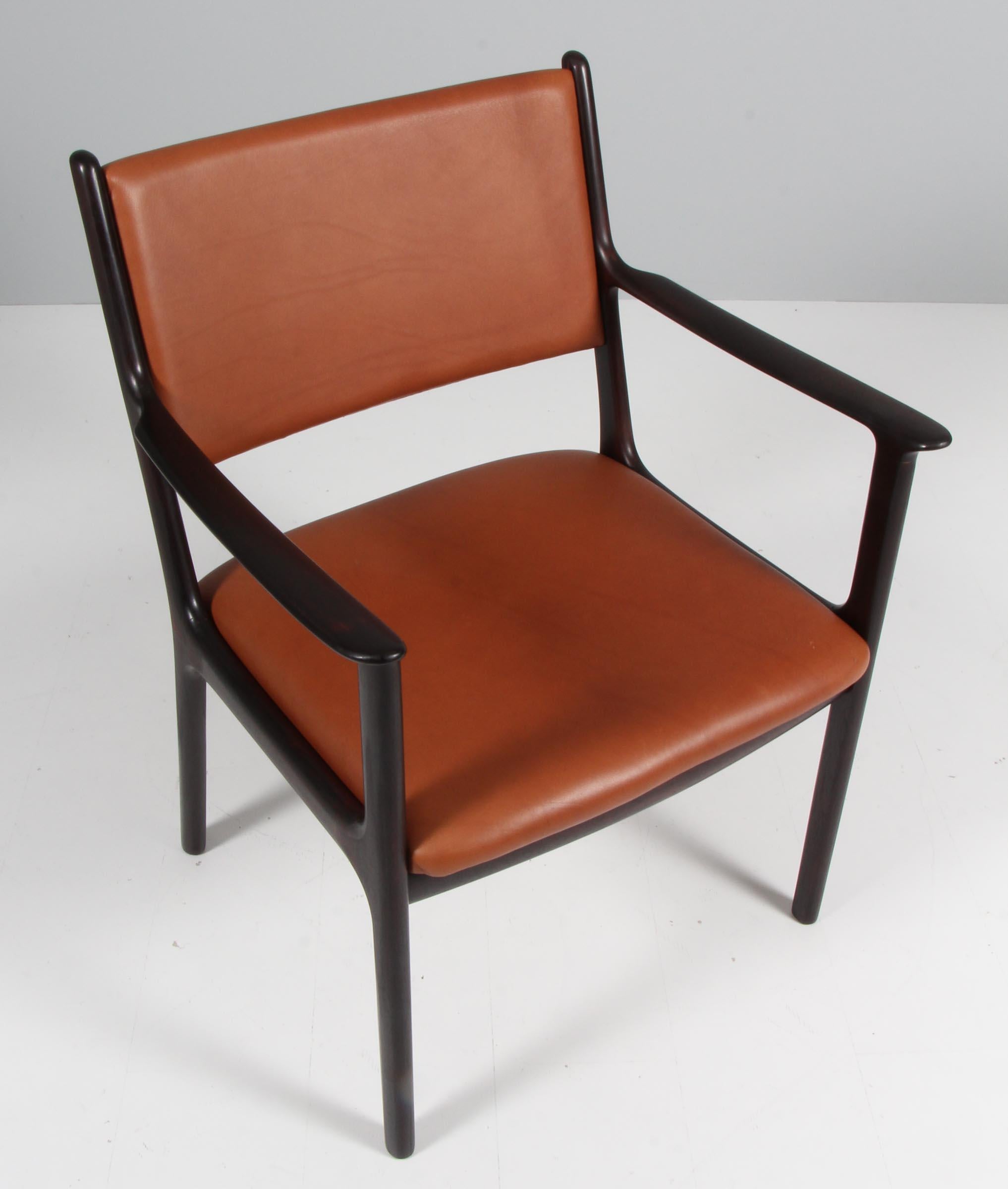 Ole Wanscher armchair new upholstered with tan pure aniline leather.

Made of solid rosewood.

Model PJ 412, made by Poul Jeppesen.

