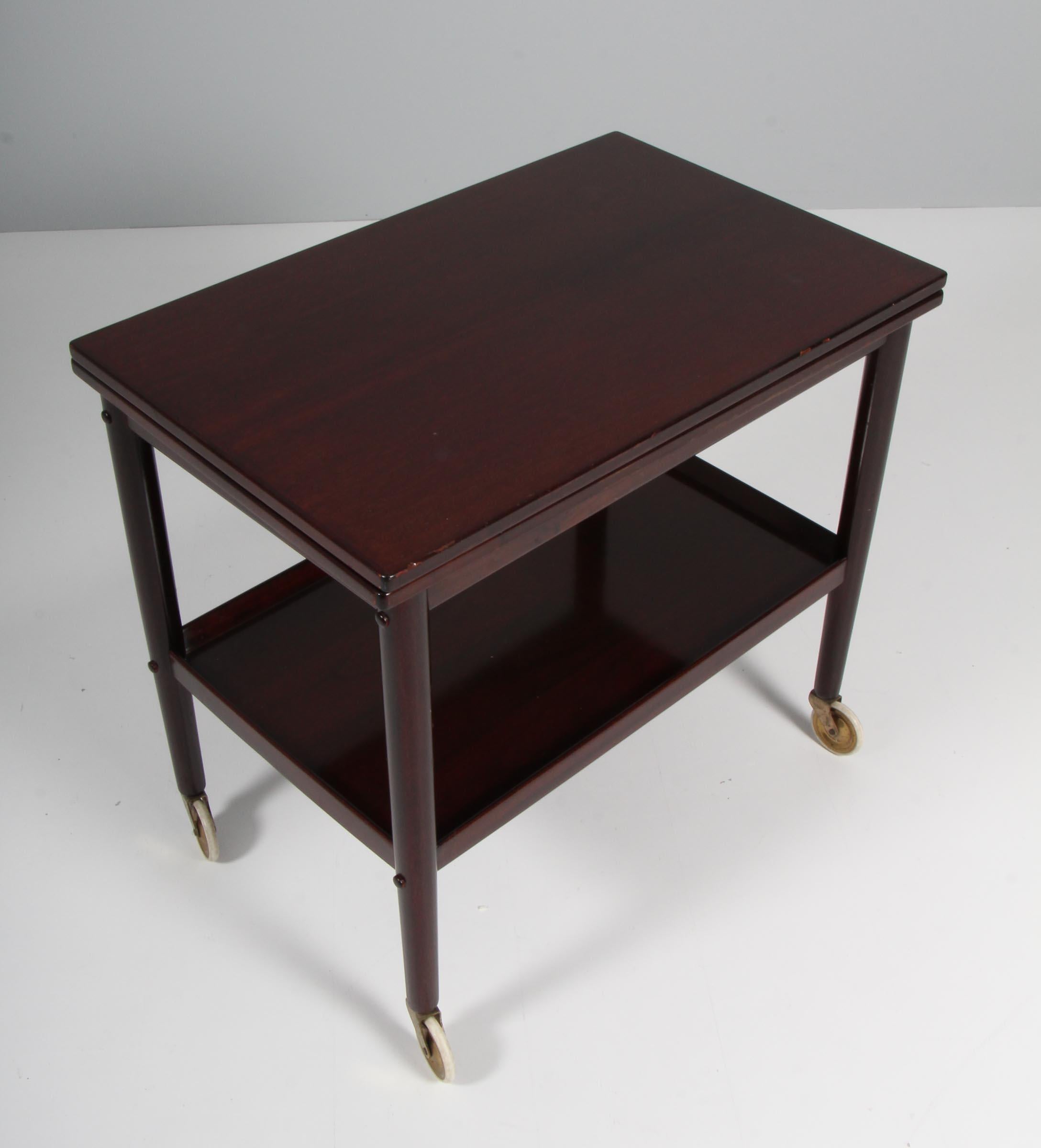 Ole Wanscher bar cart / tray cart with frame of mahogany. Foldable top with a width of 44/88 cm. 

Buttom tray of mahogany

Model Rungstedlund, made by Poul Jeppesen.

