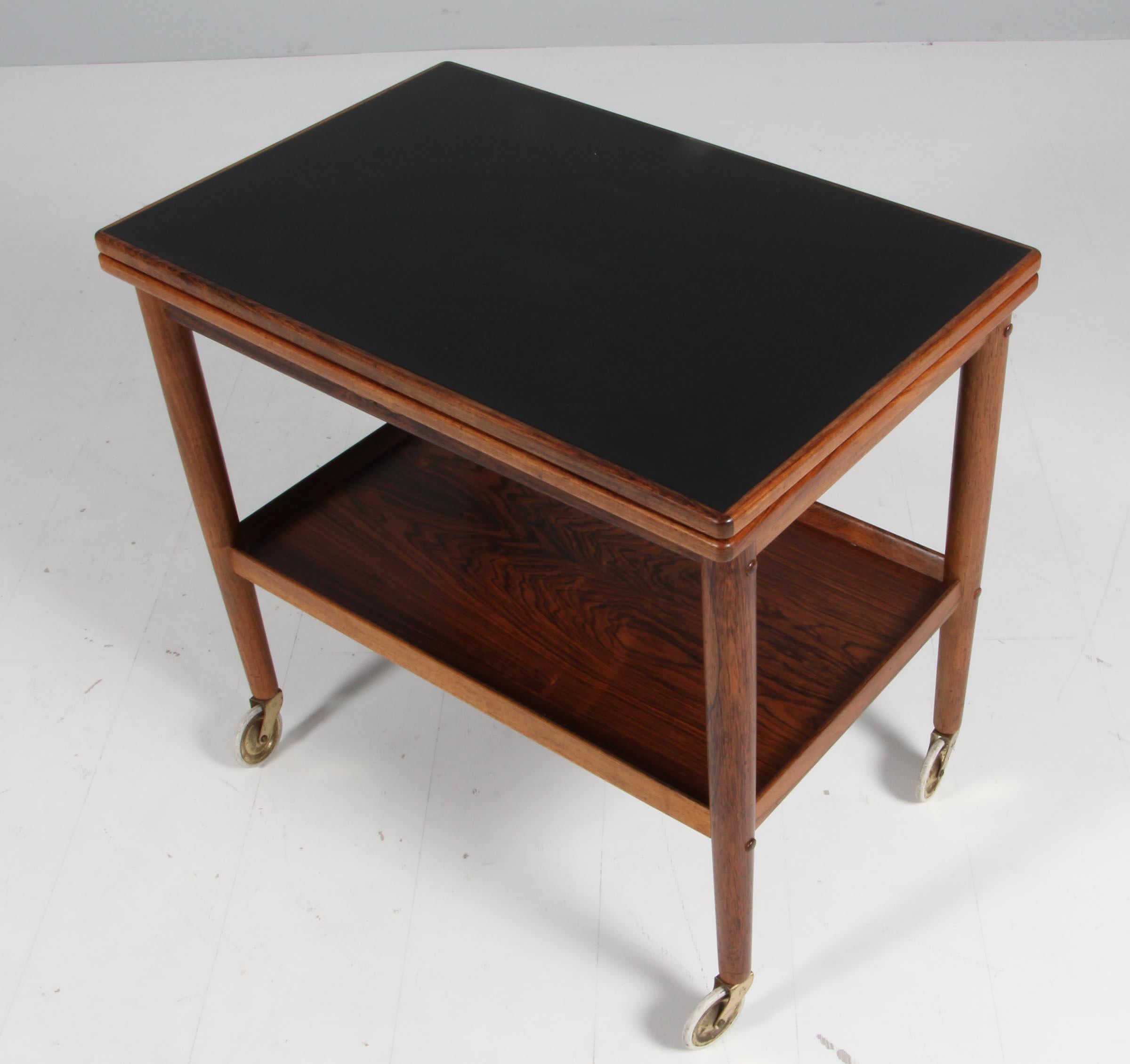 Ole Wanscher bar cart / tray cart with frame of rosewood. Foldable top with a width of 45/90 cm. With formica top.

Model Rungstedlund, made by Poul Jeppesen.


