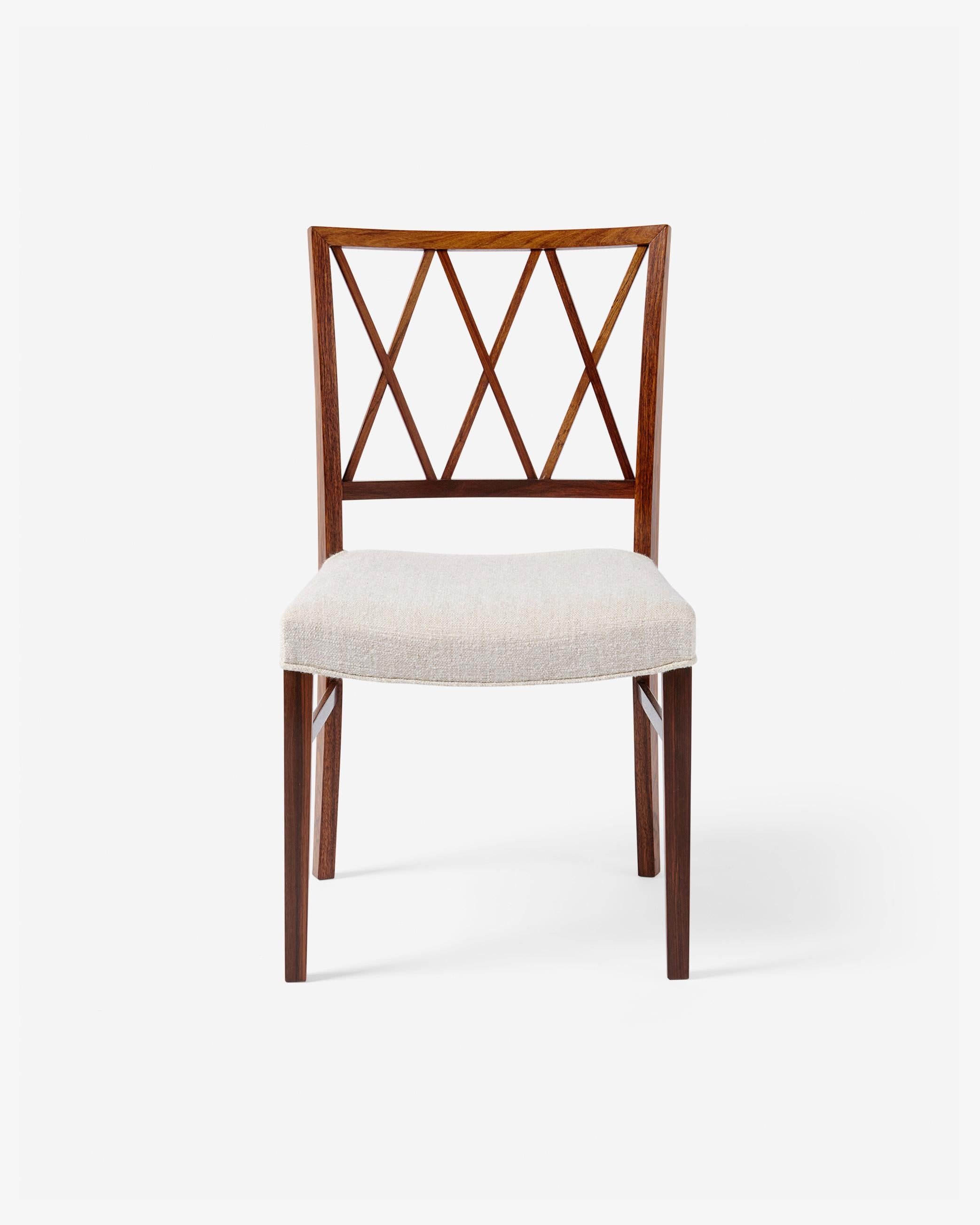 A fine example of restrained, classic furniture designer by Danish master Ole Wanscher from 1957. Produced by his long-time collaborator A.J. Iversen in fine, figured hardwood. The seat has been reupholstered in cotton-wool blend linen fabric.

