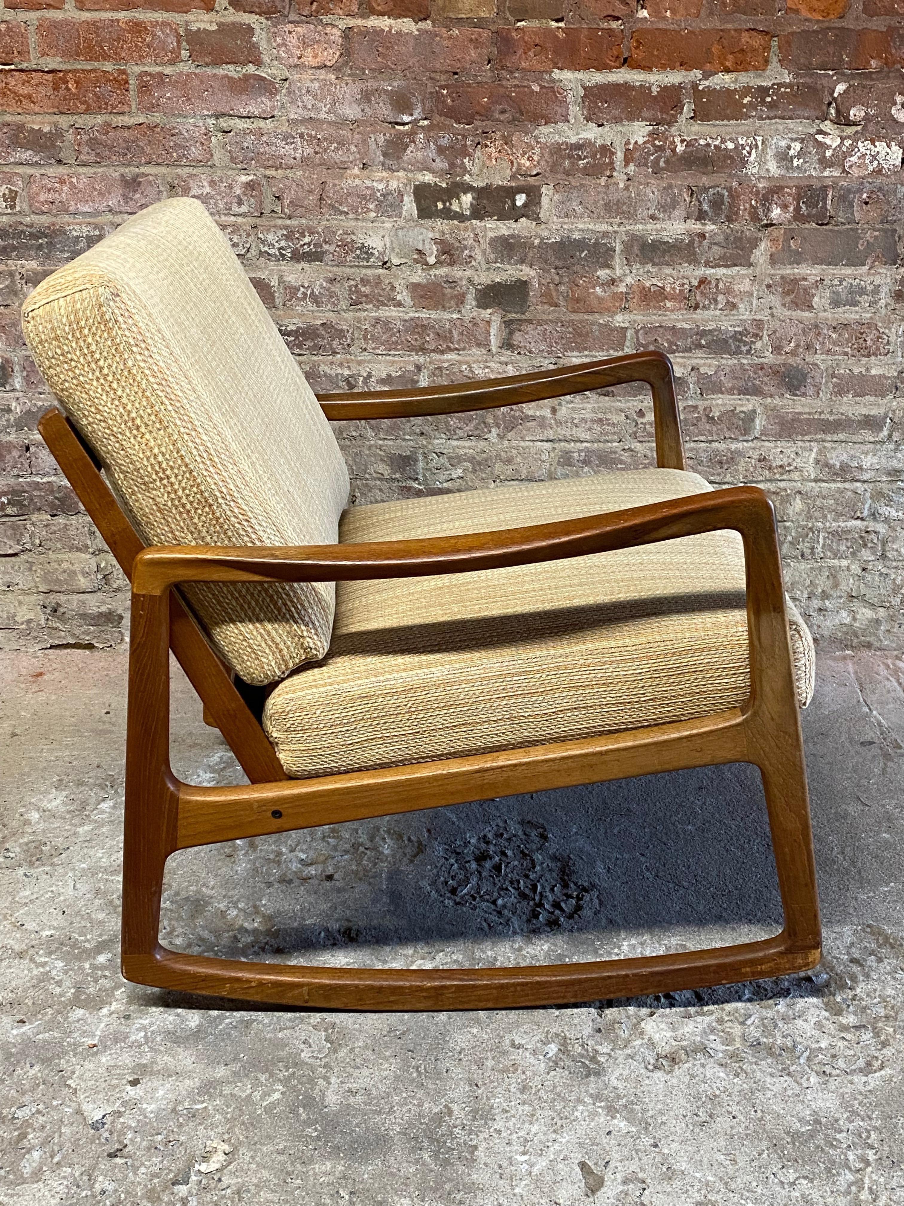 Ole Wanscher Danish Modern Model 120 rocking chair. Circa 1960-70. Solid teak frame. Retains the France and Sons button. Heavy neutral colored upholstery. 

Structurally sound and sturdy construction. Original finish and cushions.

Approximate