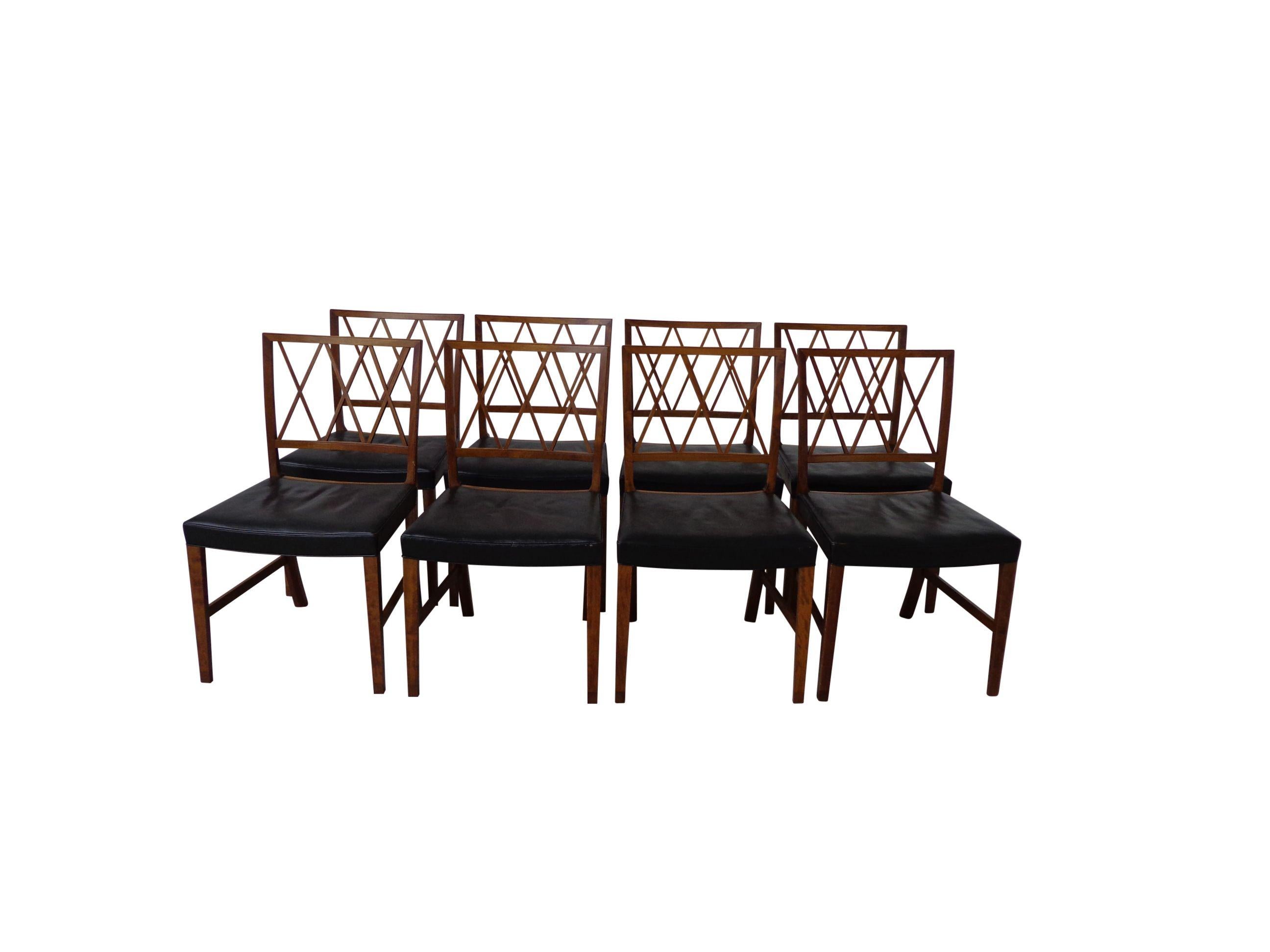 A elegant matching set of eight Ole Wanscher dining chairs upholstered in original black leather and beautiful patinated. Frame made of mahogany and shoes in rosewood. These chairs show the great craftsmanship and attention to detail that Ole