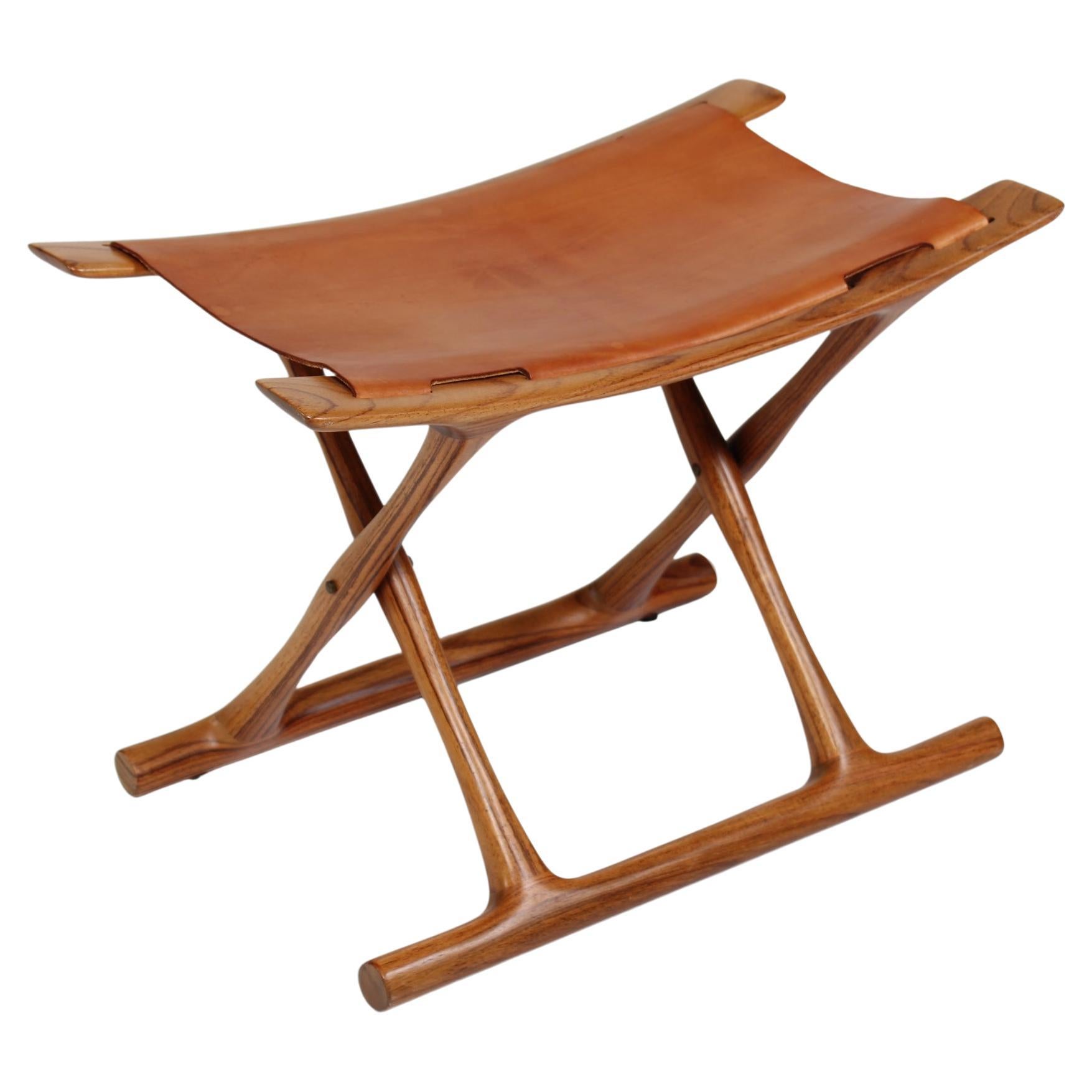 El taburete egipcio fue diseñado por Ole Wanscher (1903-1985) y labrado por primera vez en 1957 por el ebanista A. J. Iversen.
Este taburete PJ 2000 que tenemos a la venta fue fabricado por PJ Møbler en Dinamarca en 2003 para celebrar el centenario