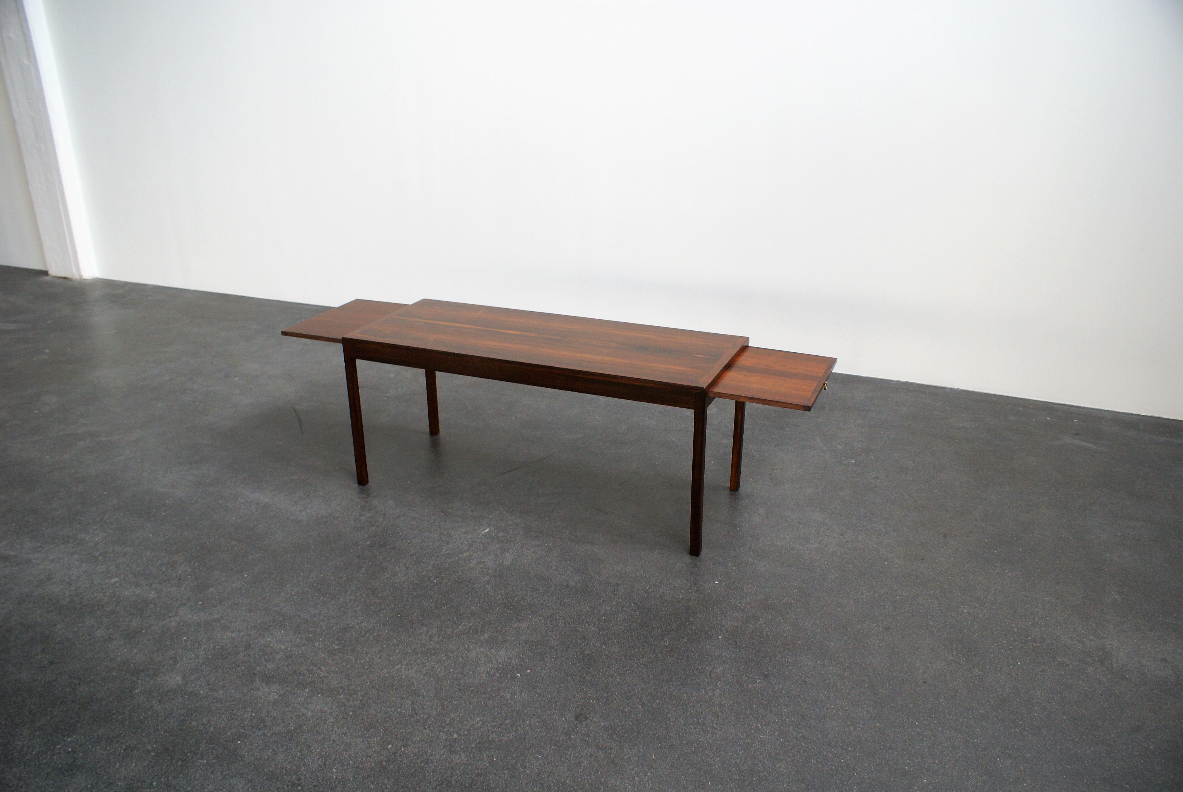 Ole Wanscher extendable low table in Brazilian rosewood and brass. Extensions to both sides of the table with brass fittings. Executed by master cabinetmaker A. J. Iversen, Copenhagen, 1950s. Paper label from Iversen under the table