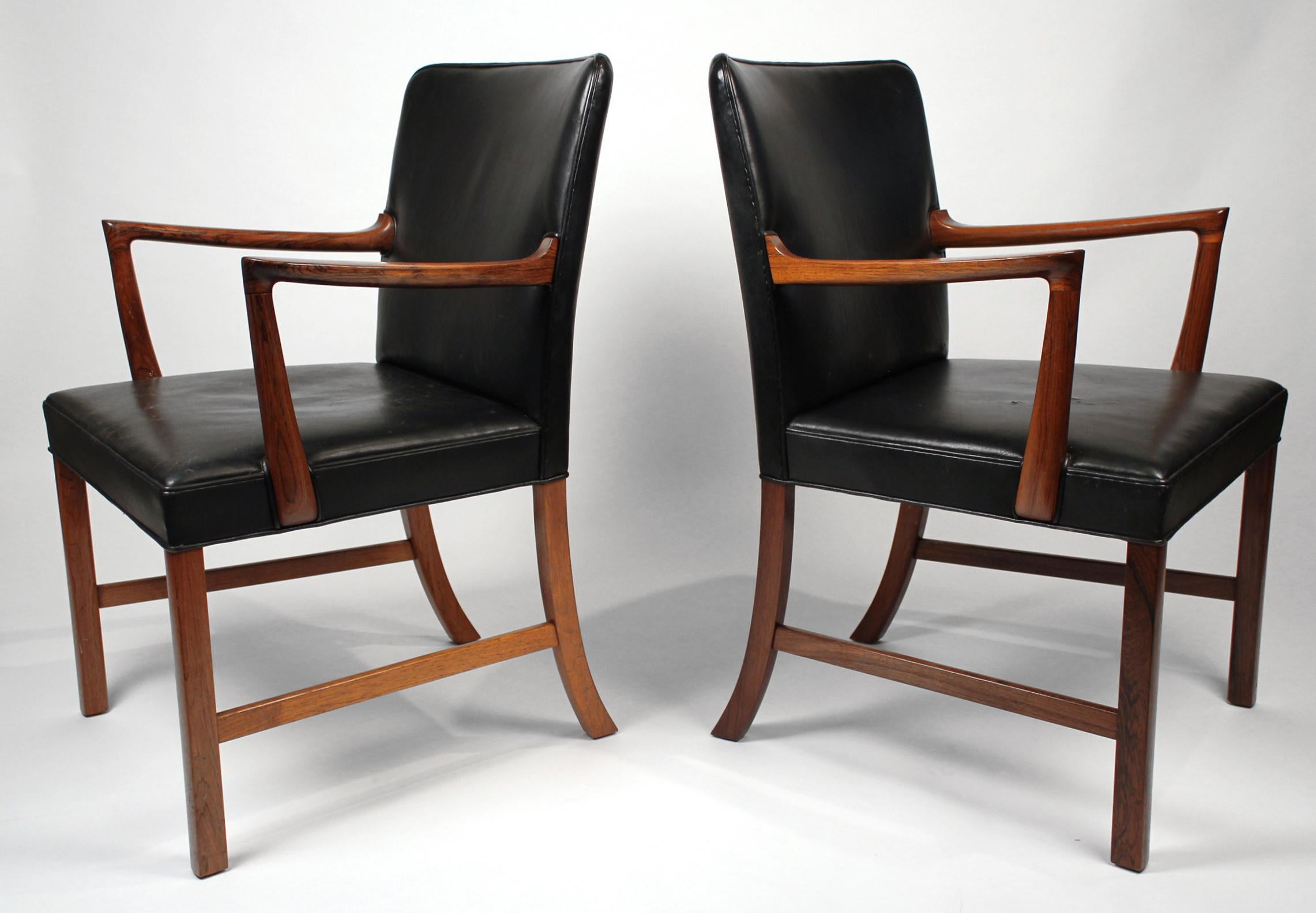 Pair of solid rosewood captain's chairs designed by Ole Wanscher, one of the leading figures in the Scandinavian design movement. These chairs were produced by A.J. Iversen Snedkermester in Copenhagen, Denmark in 1960. This pair originated from the