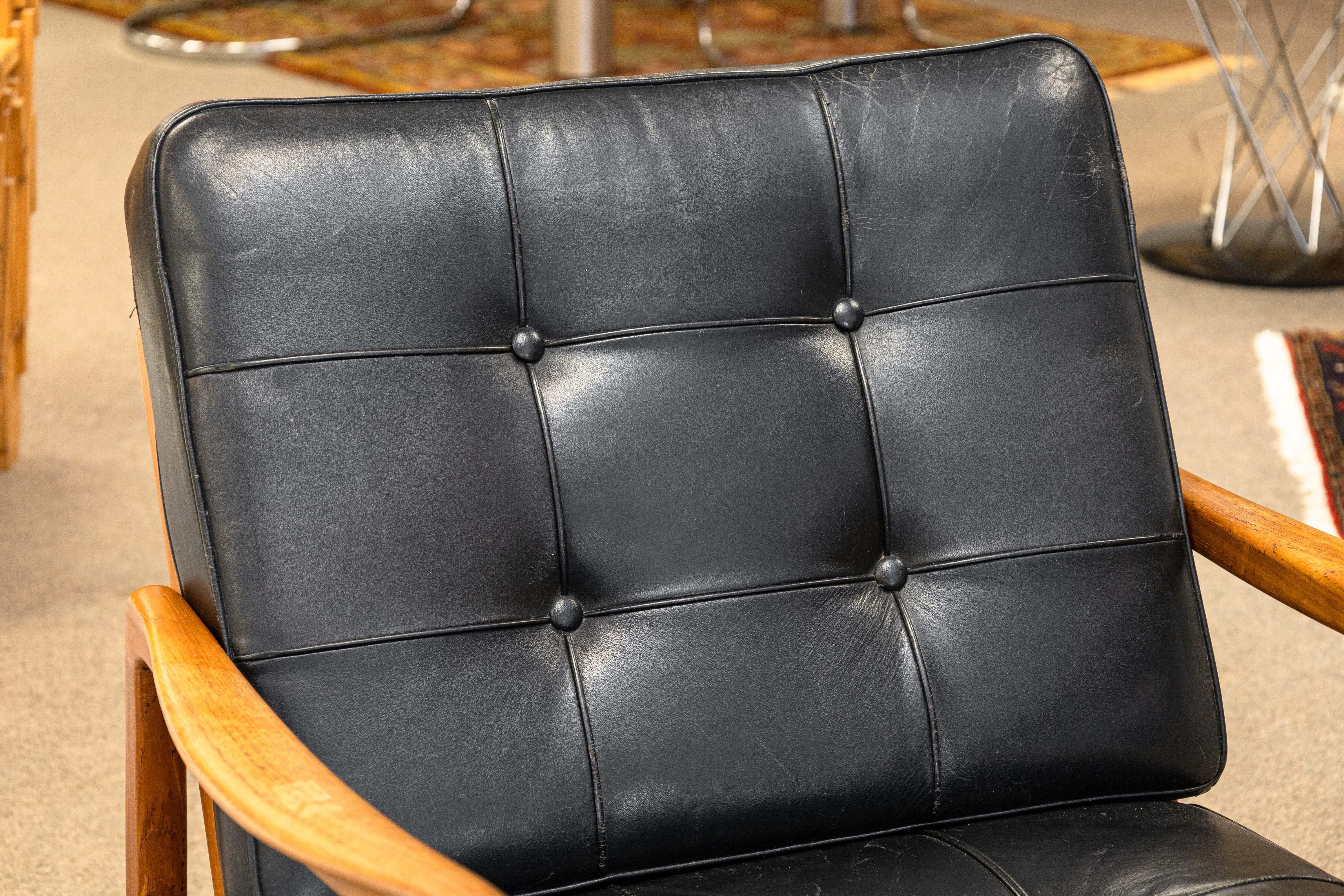 Fauteuil d'appoint à bascule Ole Wanscher pour France & Sons. Il s'agit d'un fauteuil d'accent à bascule très classique du milieu du siècle dernier. Cette chaise est dotée d'un cadre en bois de teck sculpté avec de belles lignes et des bords