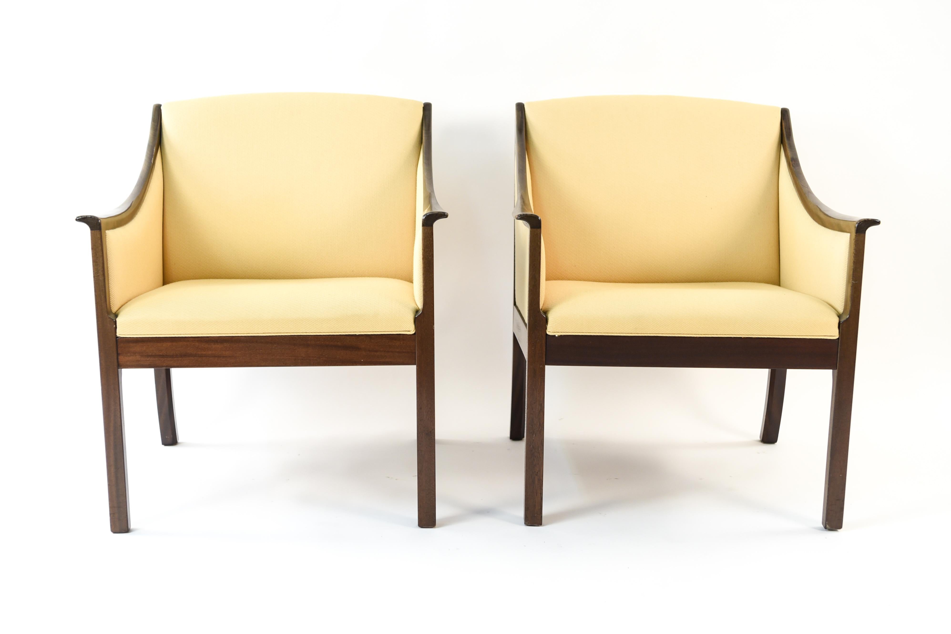 This pair of lounge chairs, circa 1950s was designed by Ole Wanscher for Poul Jeppesen. This pair embodies Ole Wanscher's ability to design furniture that embraces a traditional outlook with a modern twist. Featuring high quality mahogany frames.
