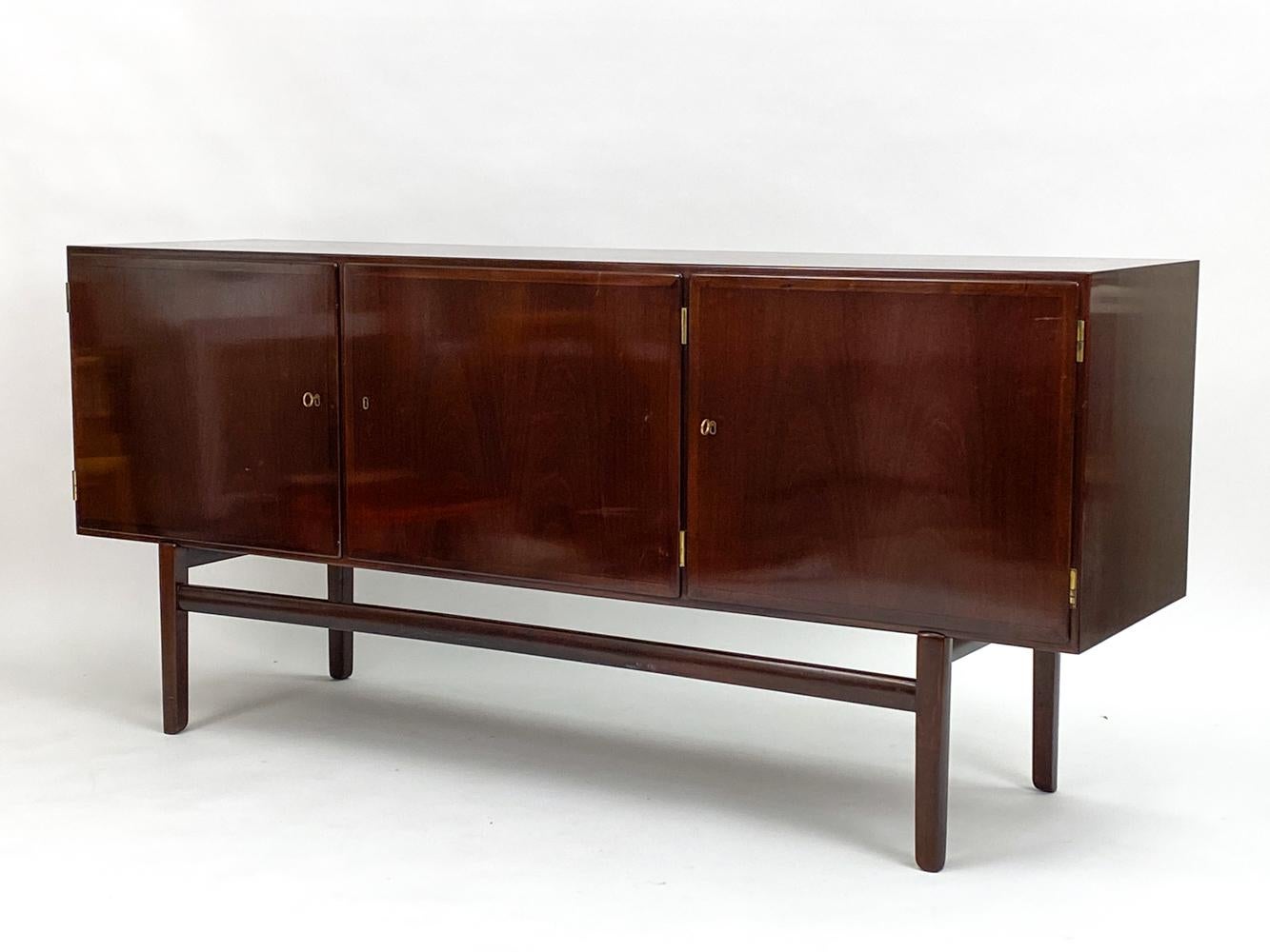 An iconic piece of Danish design history, the Rungstedlund sideboard by Ole Wanscher is timeless in its exquisite luxury and minimalist silhouette. Produced by Poul Jeppesens Furniture in St Heddinge, Denmark, during the 1960's and 1970's, the