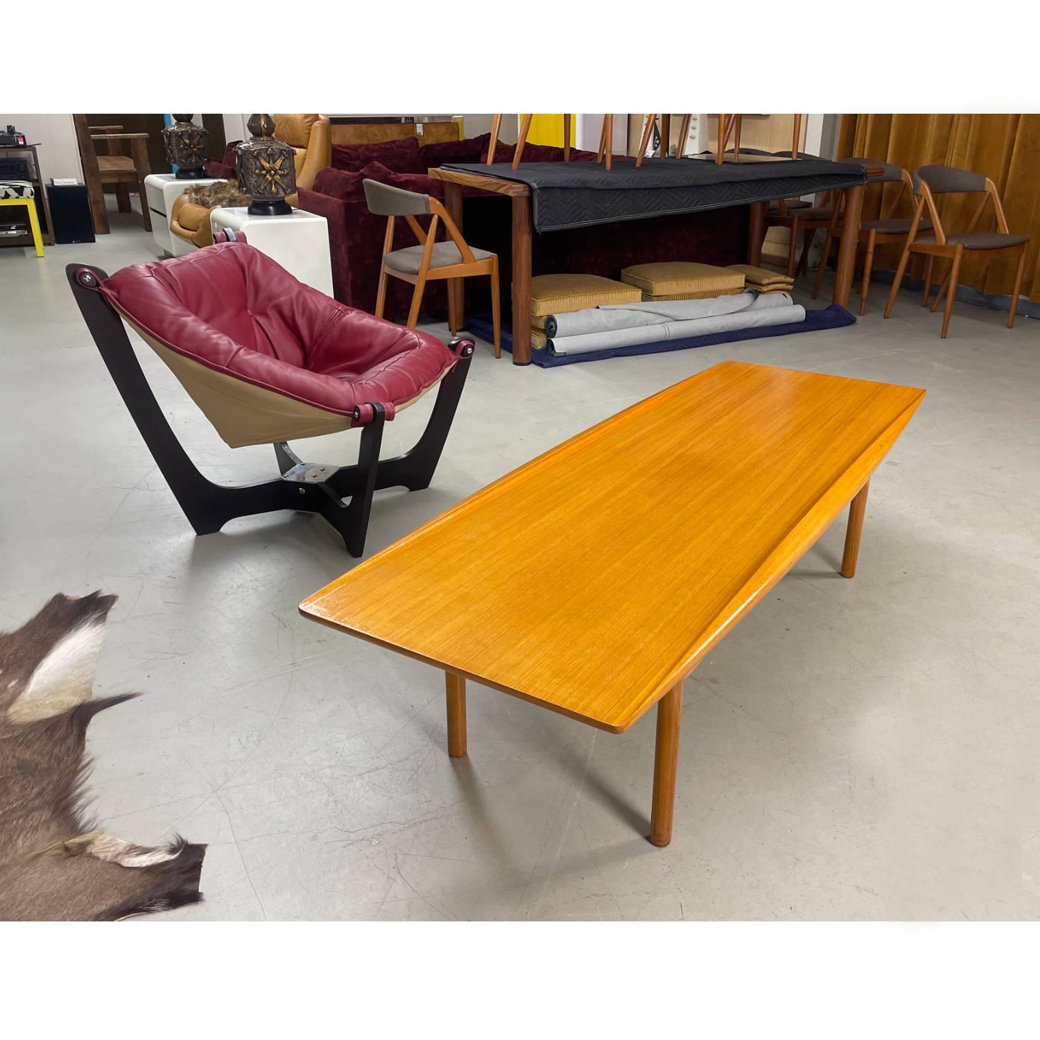 Nous avons le plaisir de vous présenter cette table basse en teck d'origine danoise, très rare, de type planche de surf, signée Ole Wanscher. Conçu par Wanscher pour Poul Jeppesens Mobelfabrik au Danemark. Vous avez peut-être vu le tableau