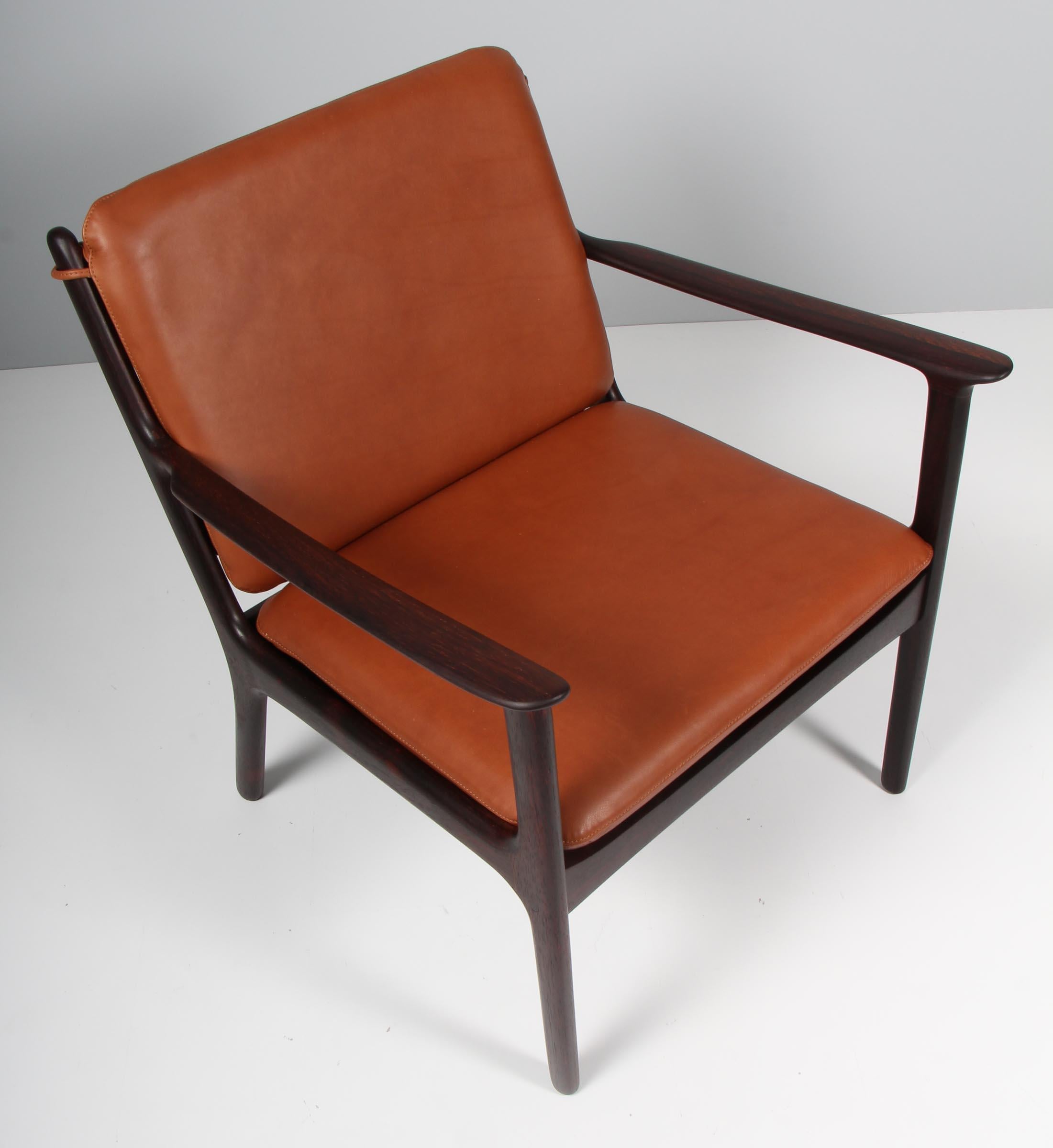 Ole Wanscher lounge chair new upholstered in brandy coloured aniline leather. 

Made of solid oiled rosewood.

Model PJ 112, made by Poul Jeppesen.

 