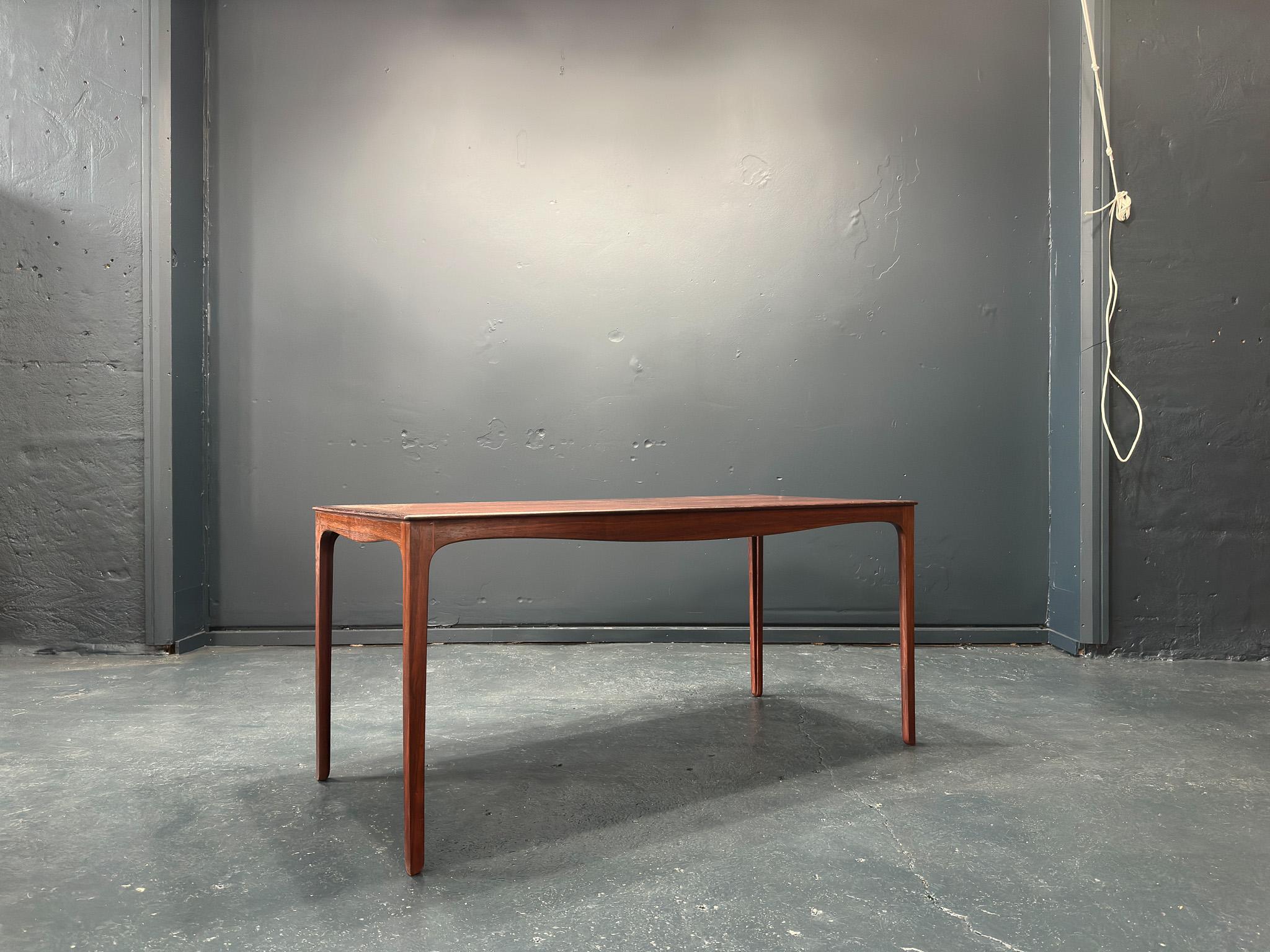 Cette table a été conçue par Ole Wanscher pour le maître ébéniste A. J. Iversen dans les années 1950. D'un design très élégant, cette table se caractérise par des pieds élancés aux courbes subtiles et par un simple cadre incurvé sous le plateau de