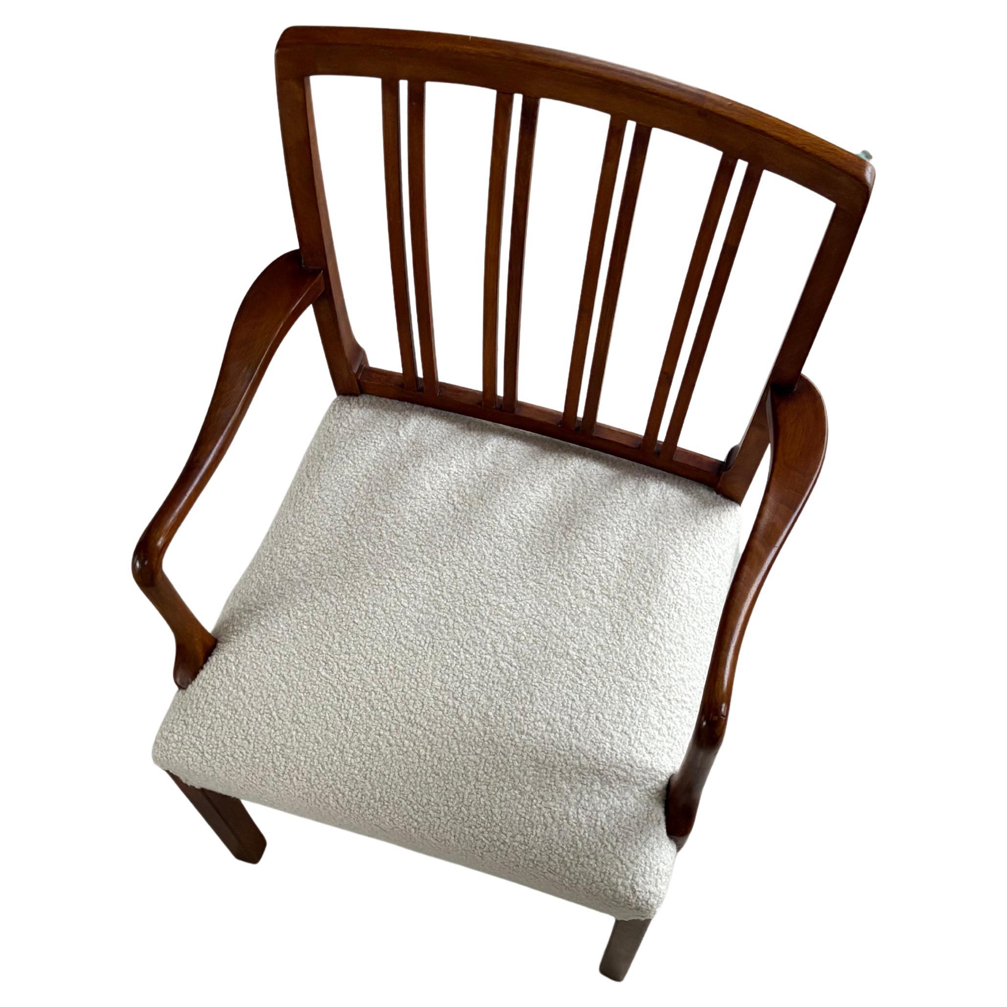 Dieser Stuhl ist ein schönes Beispiel für einen Ole Wanscher Esszimmerstuhl mit Armlehnen, der vermutlich in den 1970er Jahren von Fritz Hansen hergestellt und mit Wolle Boucle neu gepolstert wurde. Der Rahmen ist höchstwahrscheinlich aus indischem