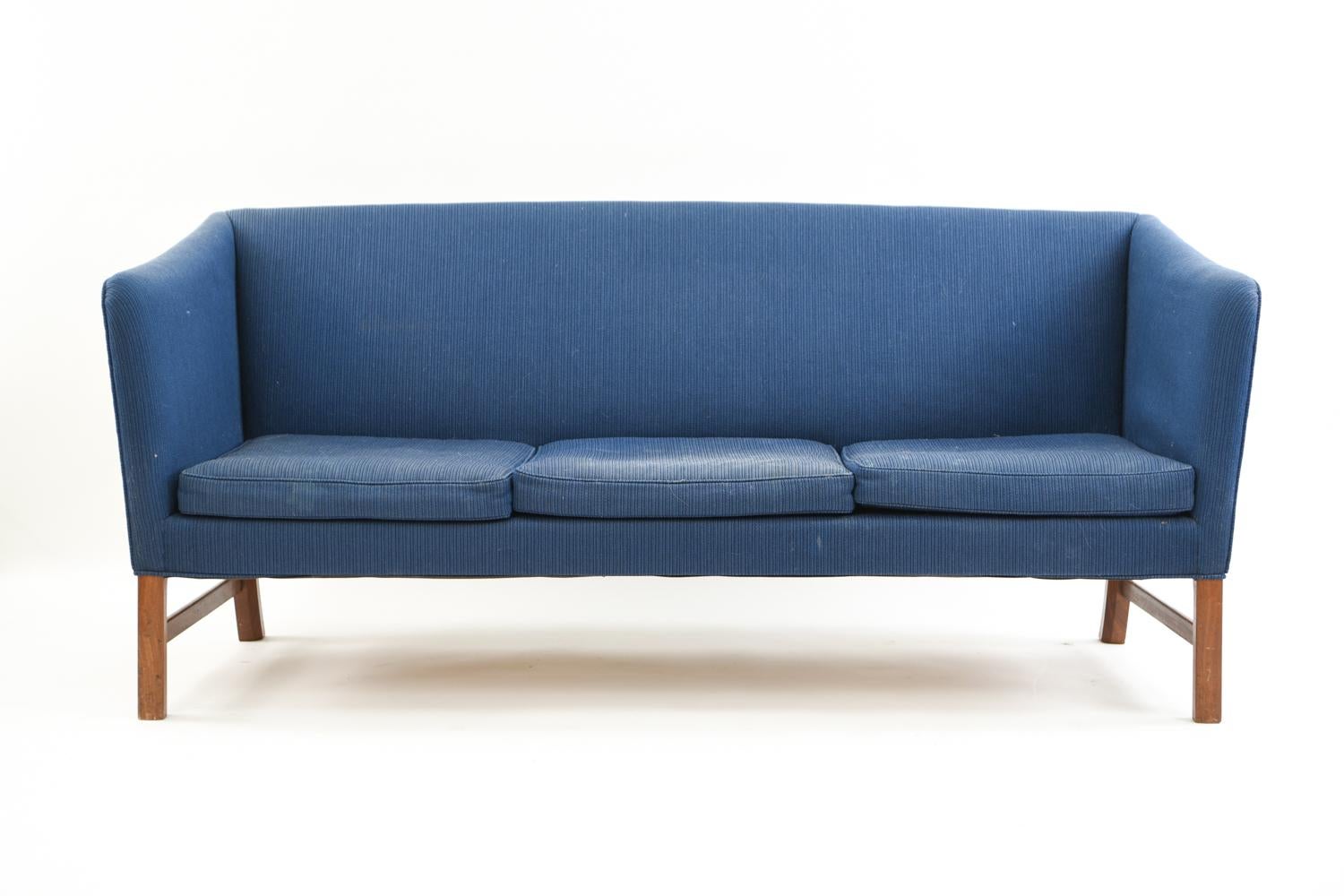 This three-seat Danish midcentury sofa was designed by Ole Wanscher. With a mahogany frame and upholstered body, this sofa would be a wonderful clean slate to reupholster to customize to any interior.