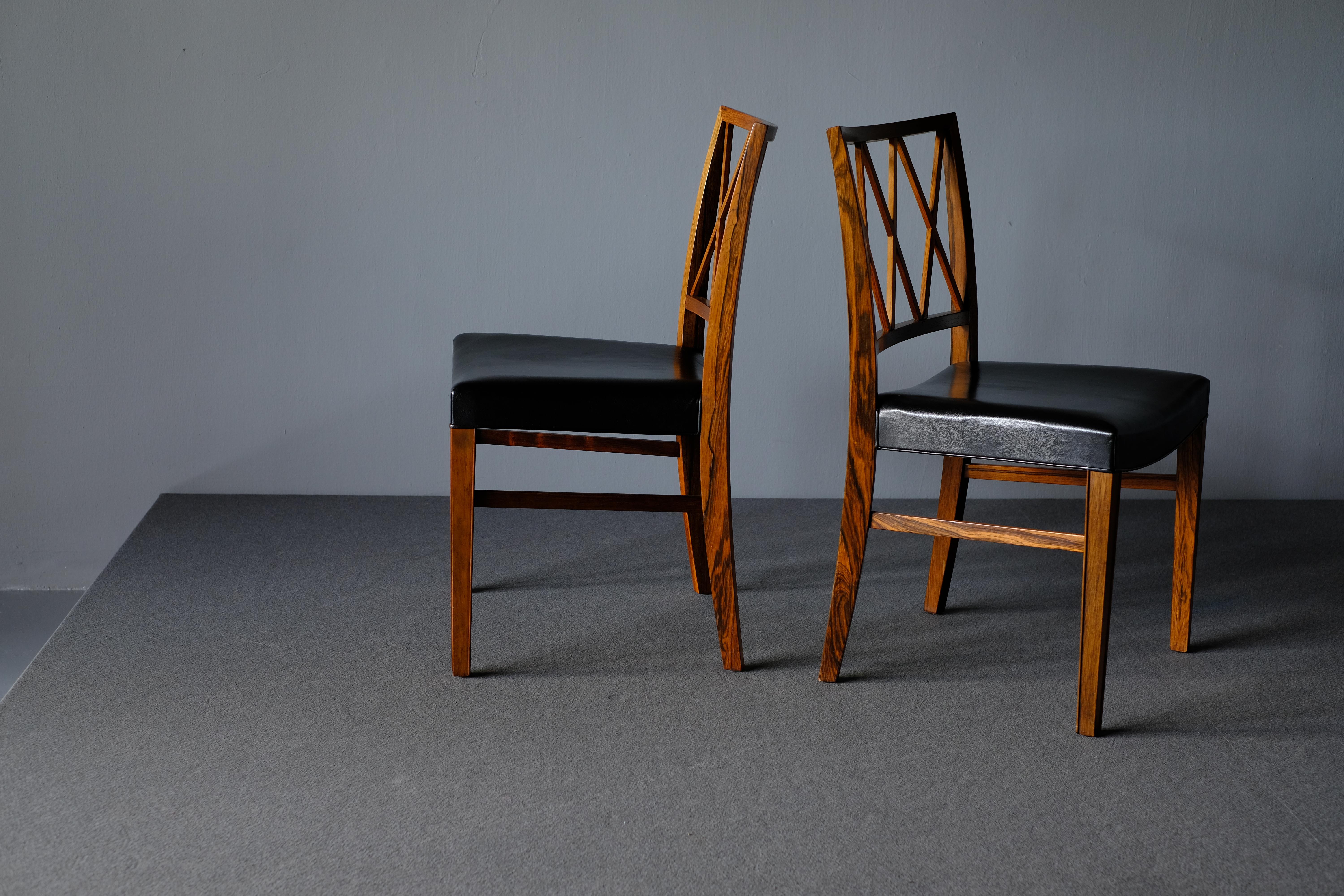 Beautiful pair of dining chairs in Brazilian rosewood designed by Ole Wanscher and produced by cabinetmaker A.J. Iversen. The pieces have refined slightly splayed legs with wonderful joinery details and are wonderfully crafted. The leather is fully