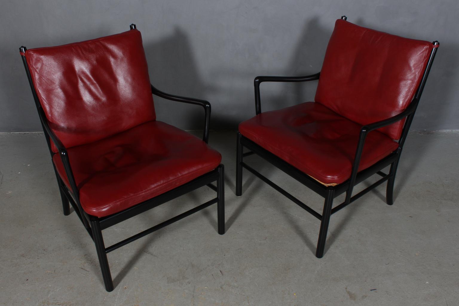 Ole Wanscher pair of lounge chairs new original upholstered with wine red leather.

Original black laquered.

Model colonial chair, made by Poul Jeppesen.