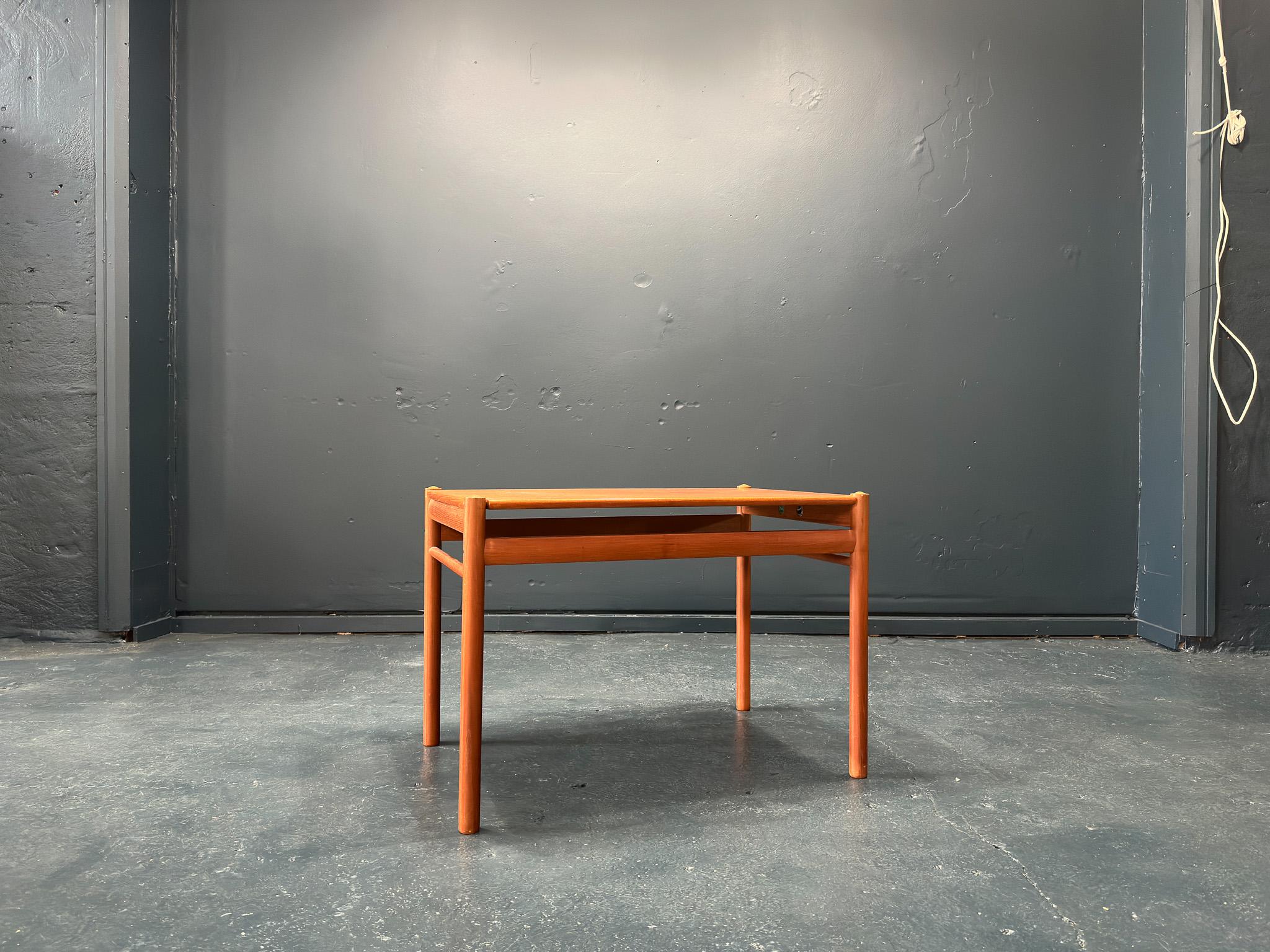 Cette pièce unique a été conçue dans les années 1960 par le designer danois Ole Wanscher pour le fabricant P. Jeppesen. La table est constituée d'un cadre en teck massif et d'un plateau réversible astucieusement conçu, dont les coins incurvés