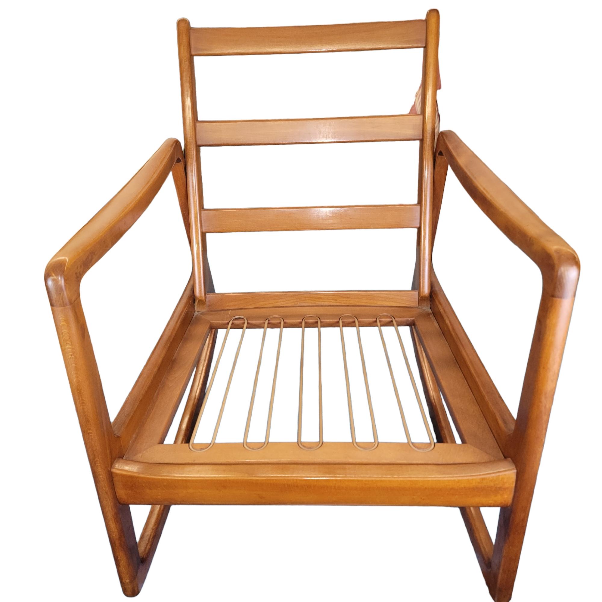 A warm-brown vintage rocker by Danish furniture designer Ole Wanscher, manufactured by France & Søn, in very good condition. The frame is made of hand carved beechwood and the chair cushions are constructed using coil springs, providing a high level