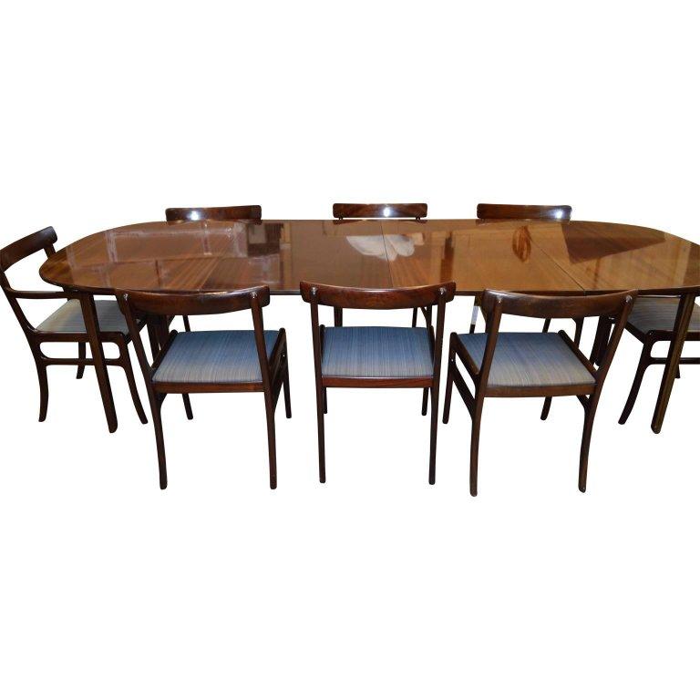 Ole Wanscher designed this dining room set for Poul Jeppesen in the 1960s. Constructed of a rich stained mahogany, and consist of two armrest chairs, six normal dining chairs, and two produced leaves for the table. The gorgeous Danish midcentury