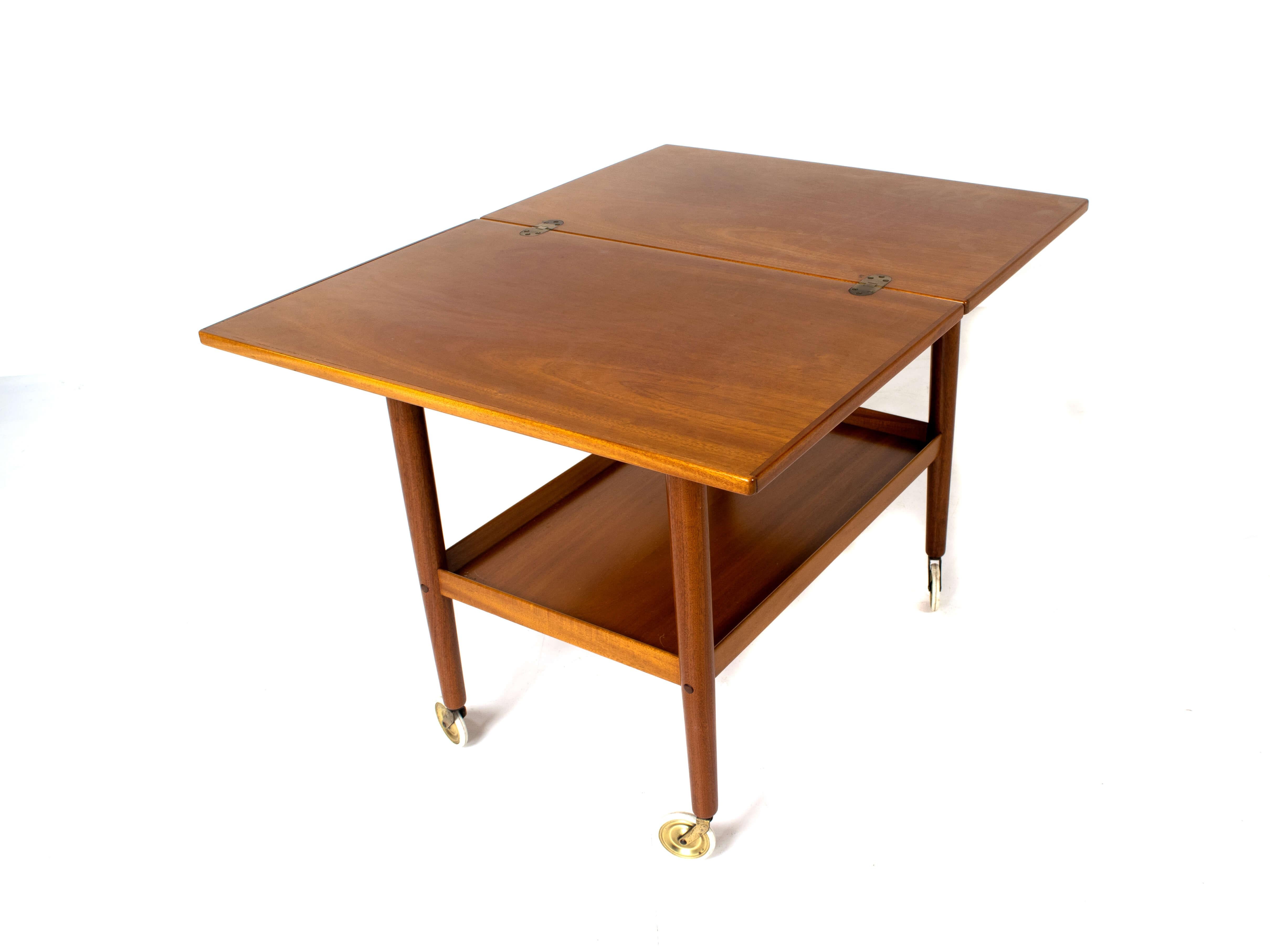 Nice Ole Wanscher serving trolley for P. Jeppesens Mobelfabrik from Denmark 1960's. This serving trolley has a top that can be folded-out to make the top twice as large; from 45 to 90 cm. The mahogany veneer is in good condition and the trolley has