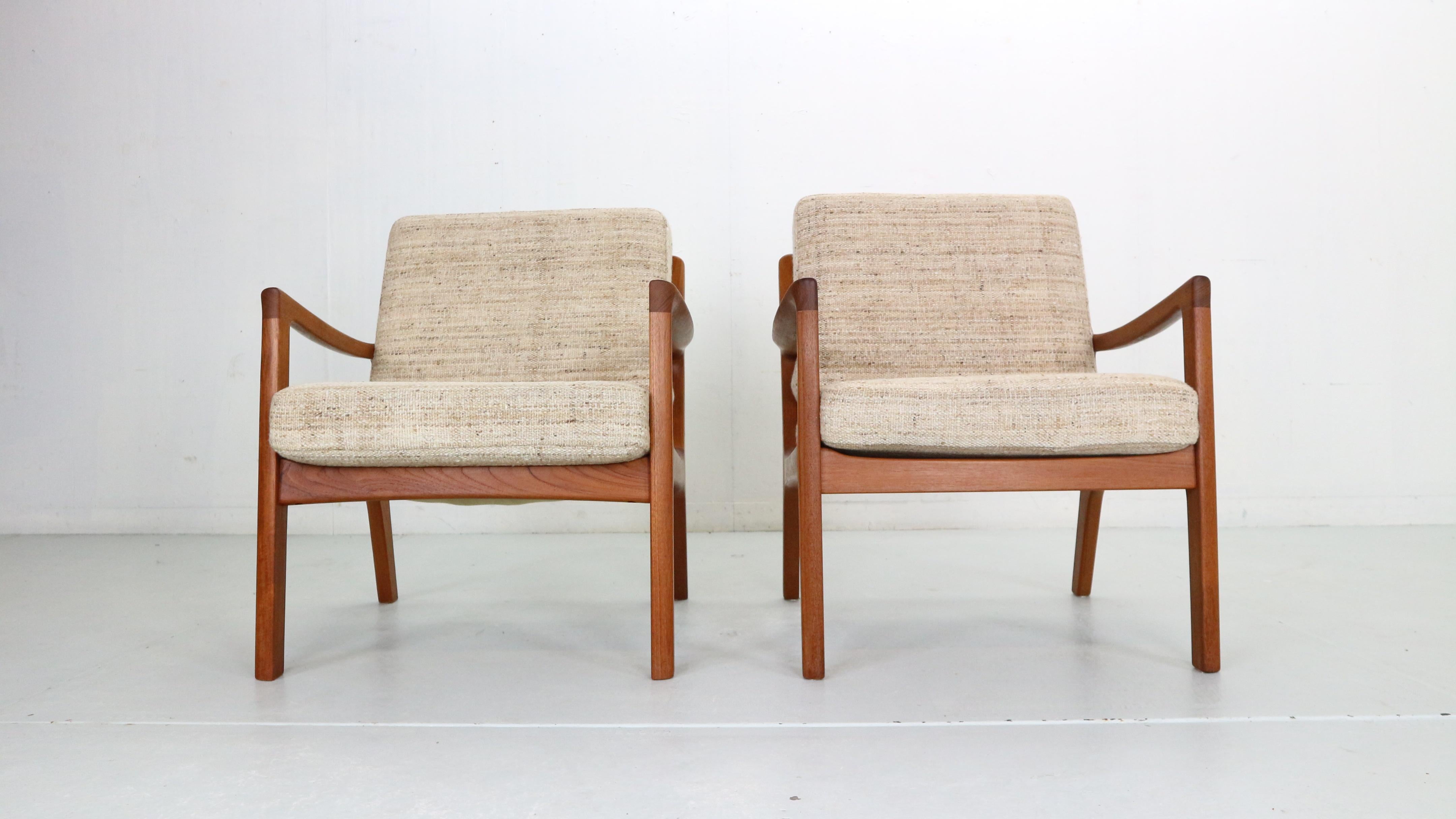 Elegant set of two lounge chairs designed by Ole Wanscher for France & Søn in Denmark, 1956.
This vintage model FD-109 lounge chairs maintains the manufacturer’s mark and features a sturdy teak wood frame with a slated open back and angled legs for